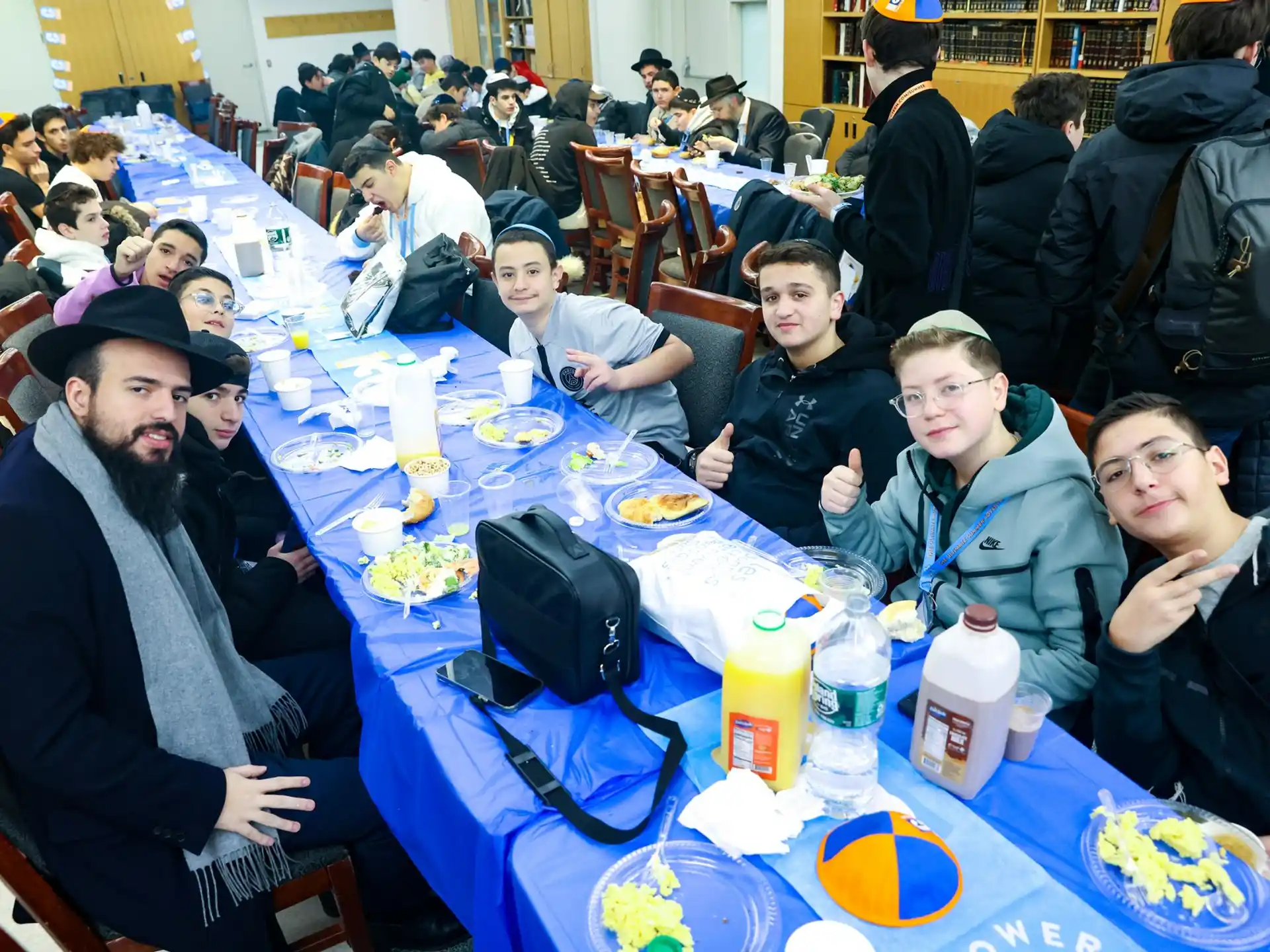 a group of people sitting at a table with food