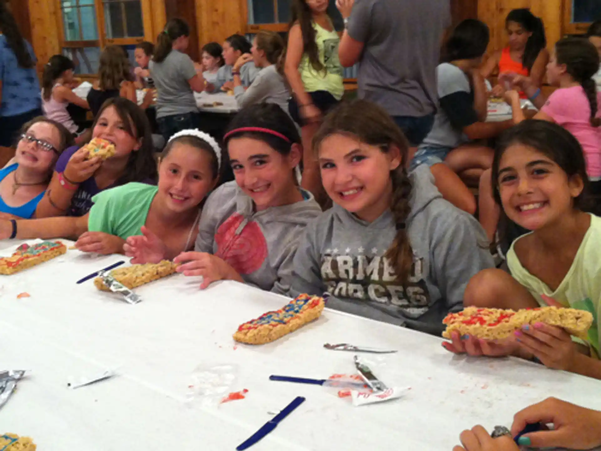 a group of people sitting at a table eating pizza