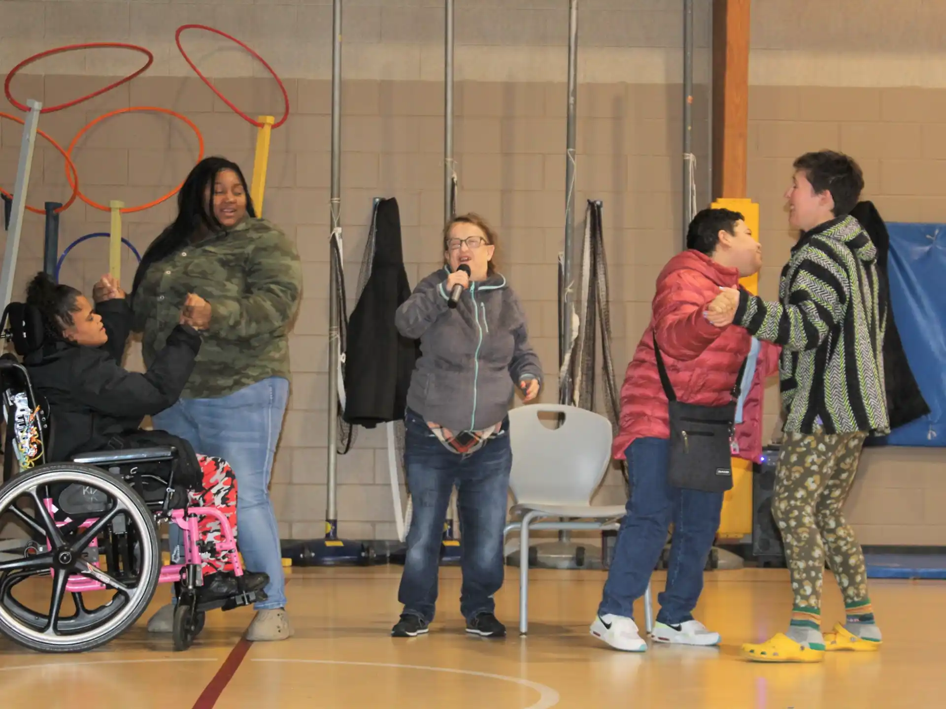 a group of people standing in a room with a person in a wheelchair
