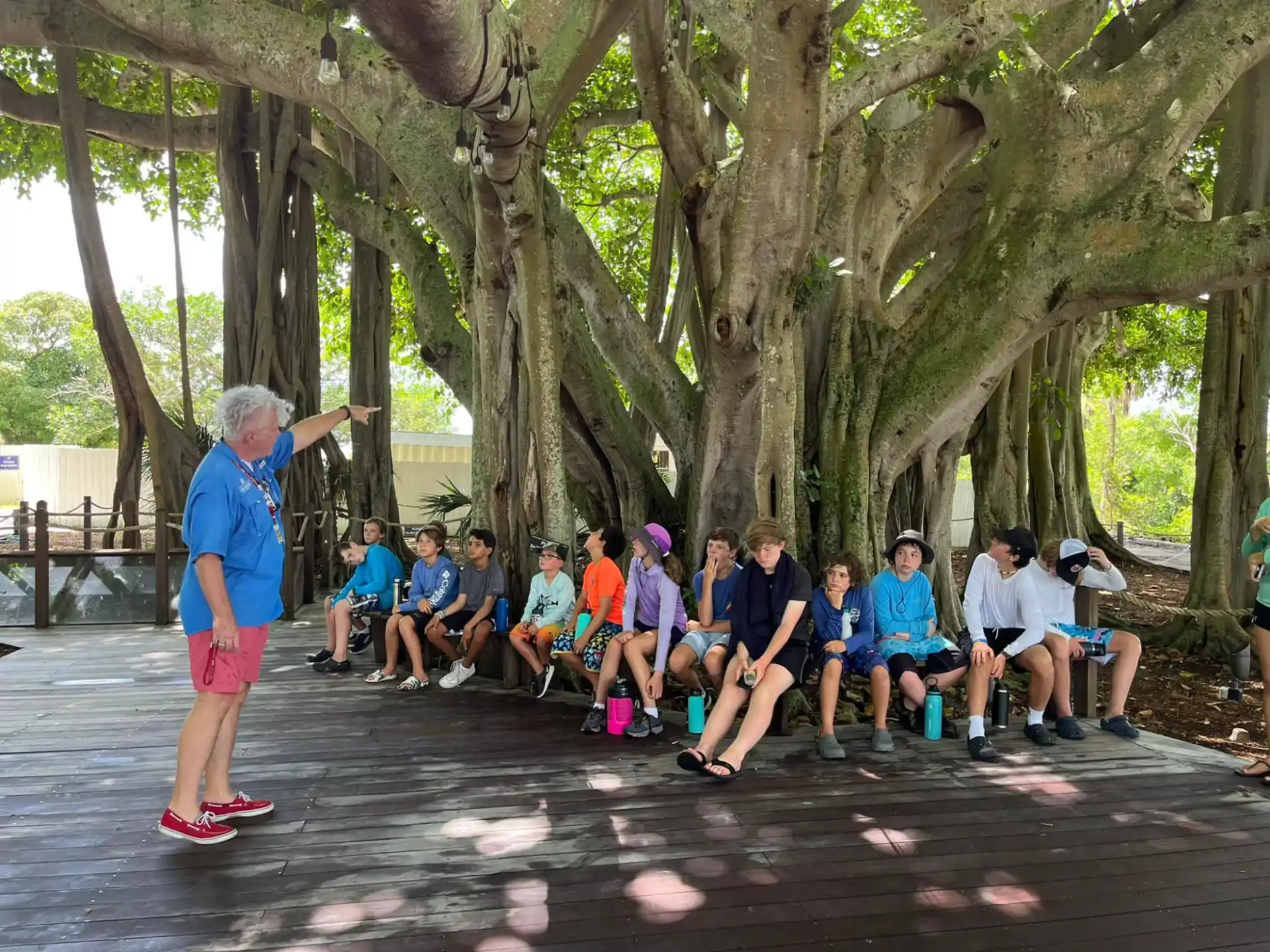a person standing in front of a group of people sitting on a bench
