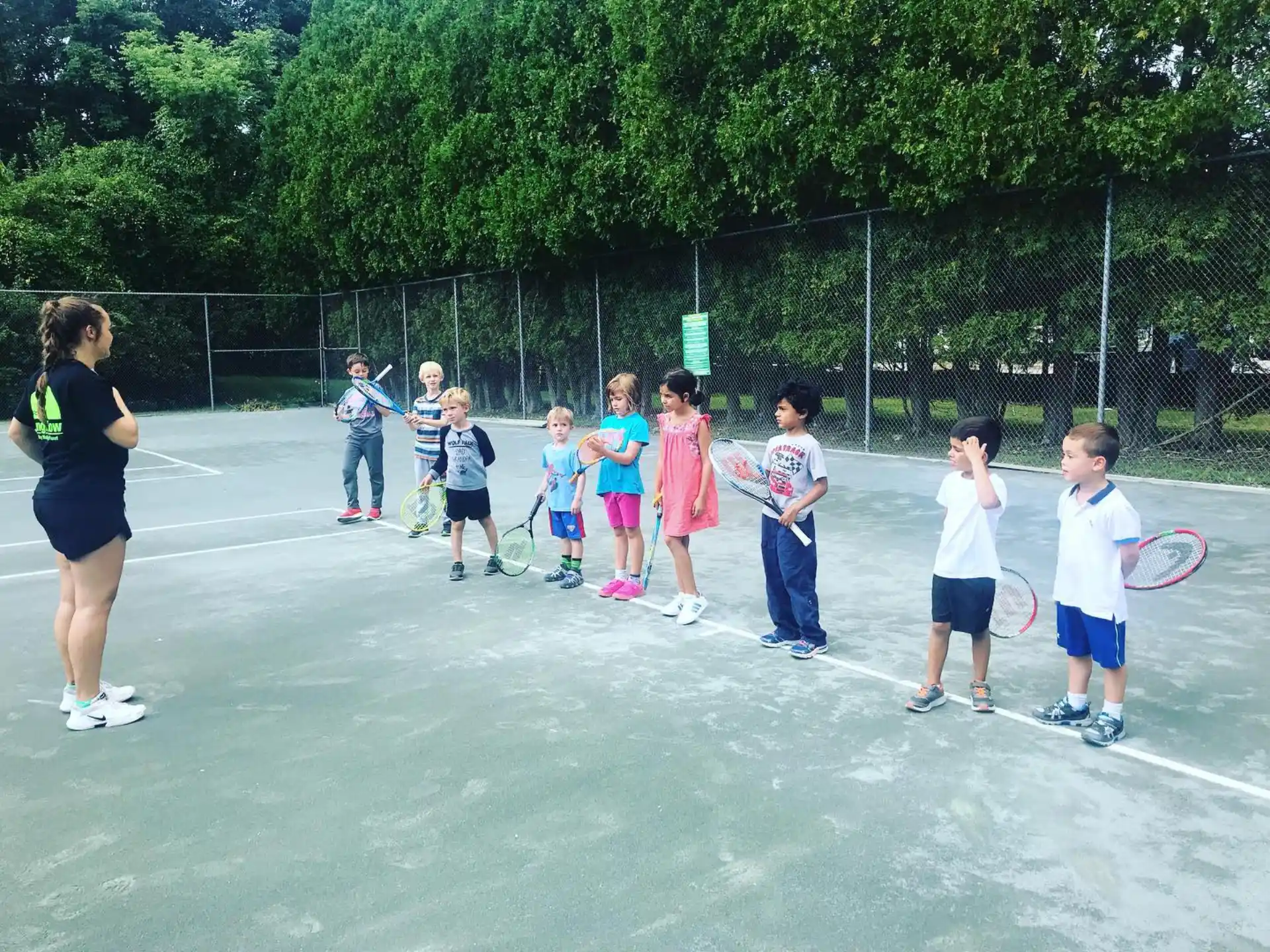 a group of kids holding tennis rackets
