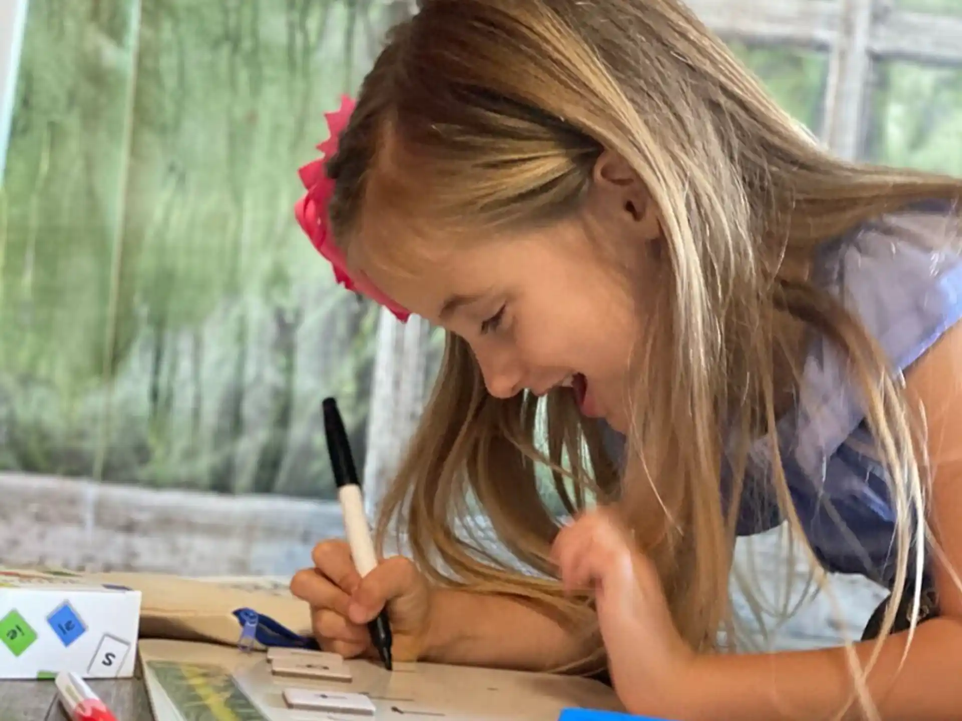 a young girl writing on a piece of paper