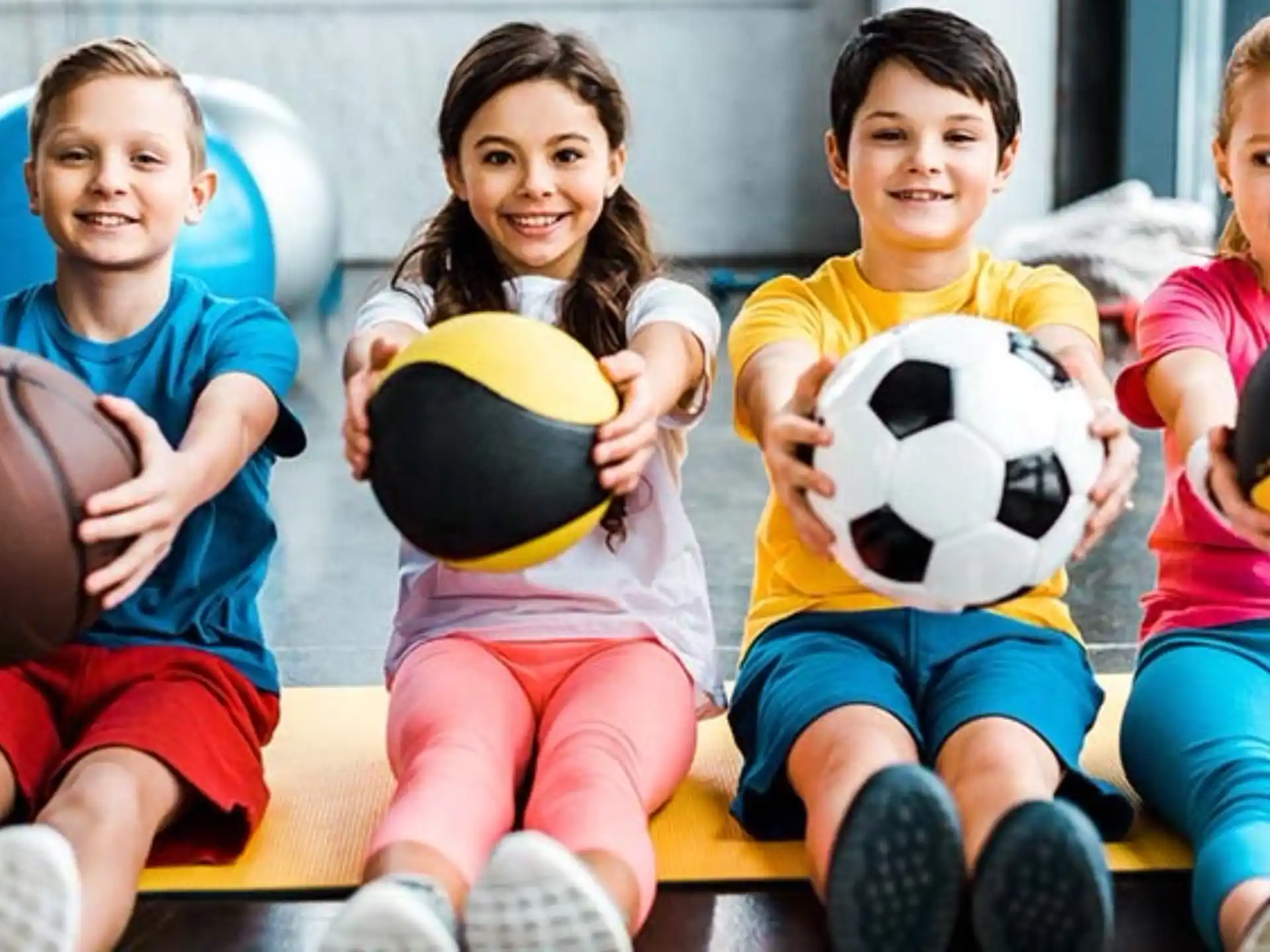 a group of kids holding football balls