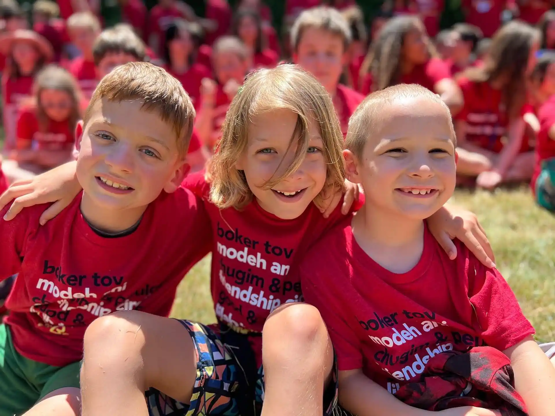 a group of children sitting on the ground posing for the camera