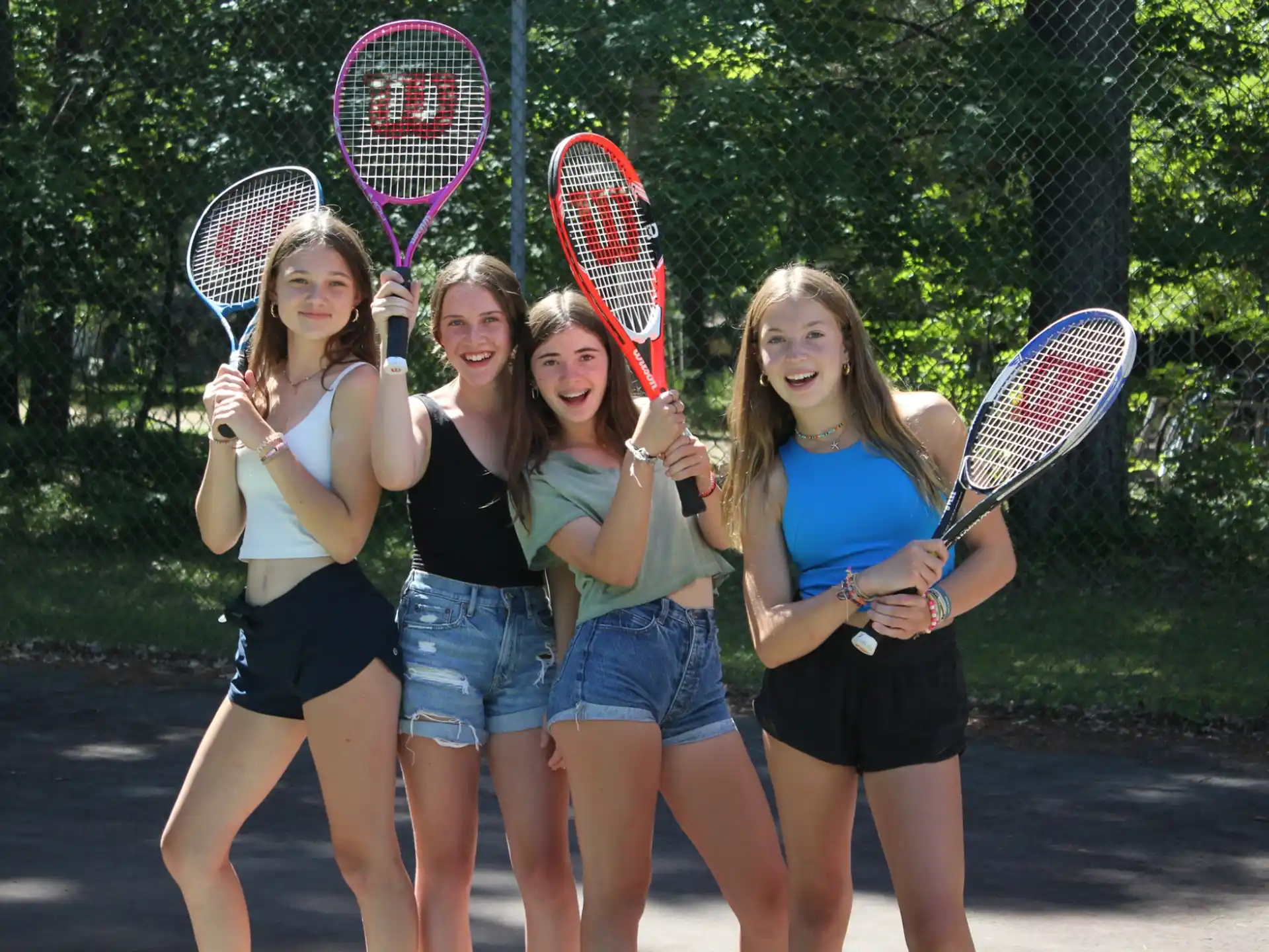 a group of girls holding tennis rackets