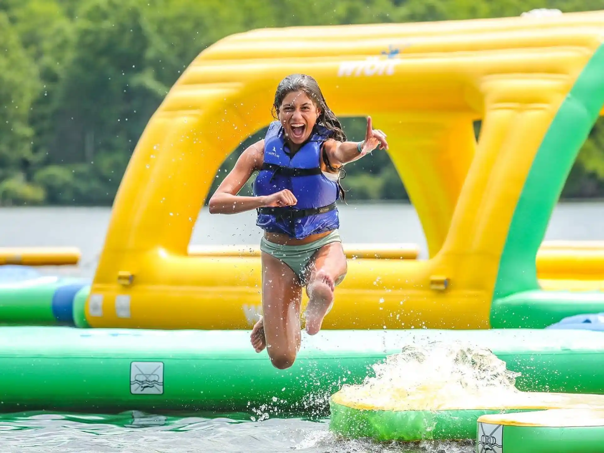 a girl jumping in a water slide