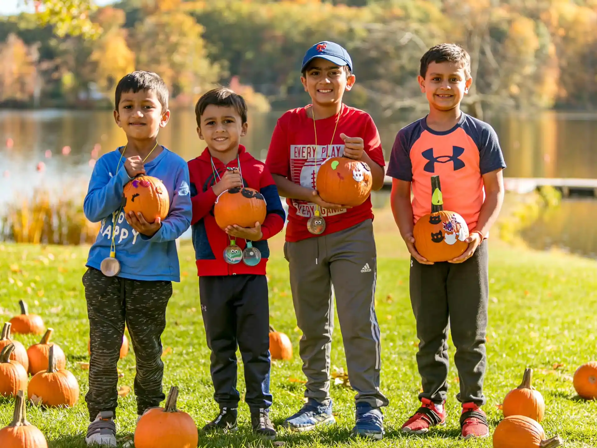 a group of boys holding pumpkins
