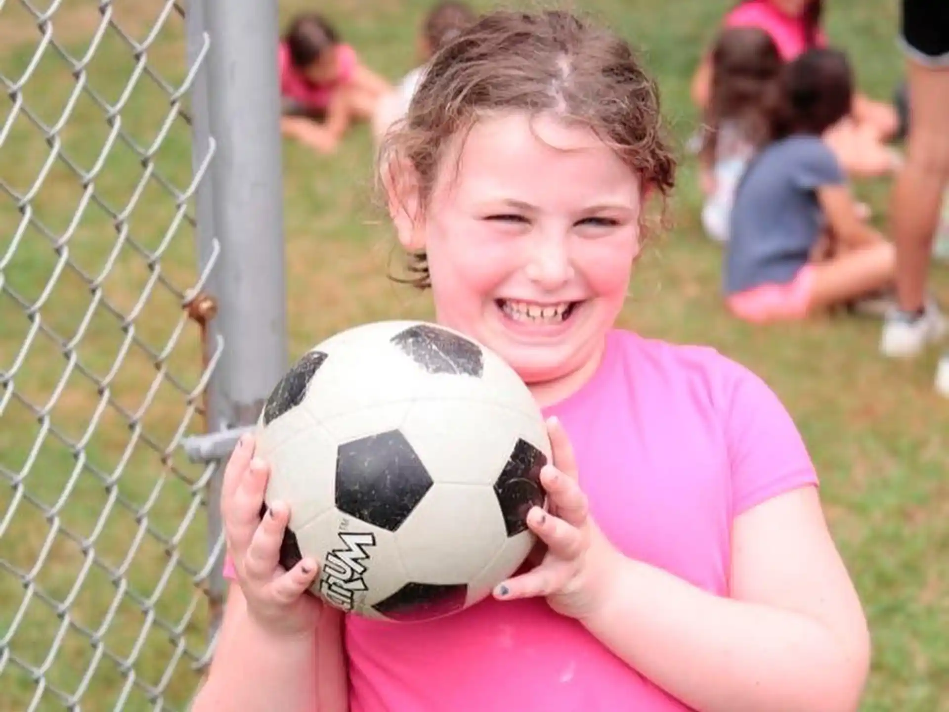 a girl holding a football ball