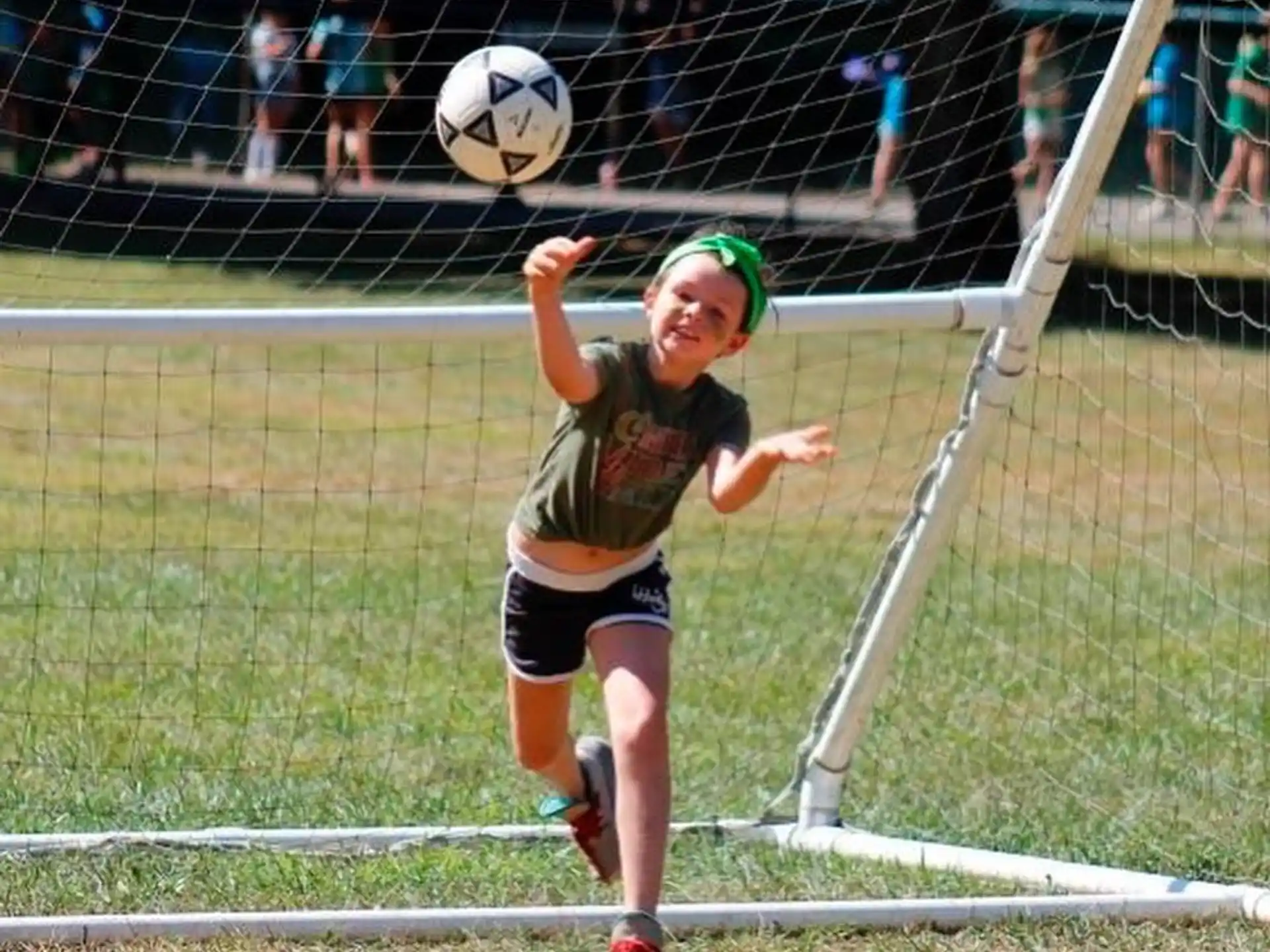 a woman hitting a football ball with her racket