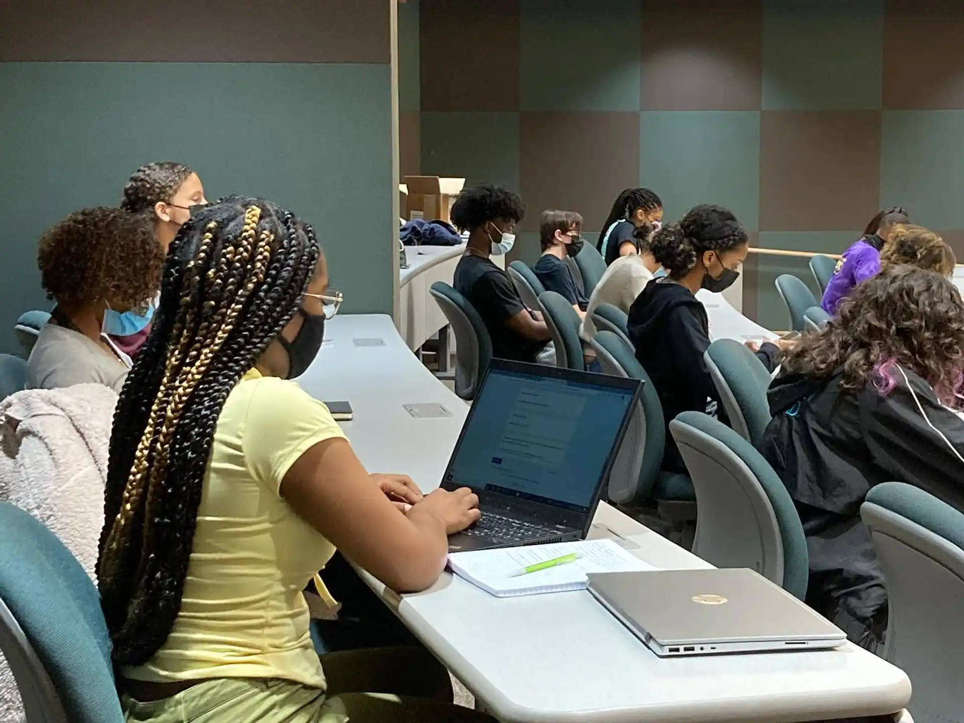 a group of people sitting at a table with a laptop
