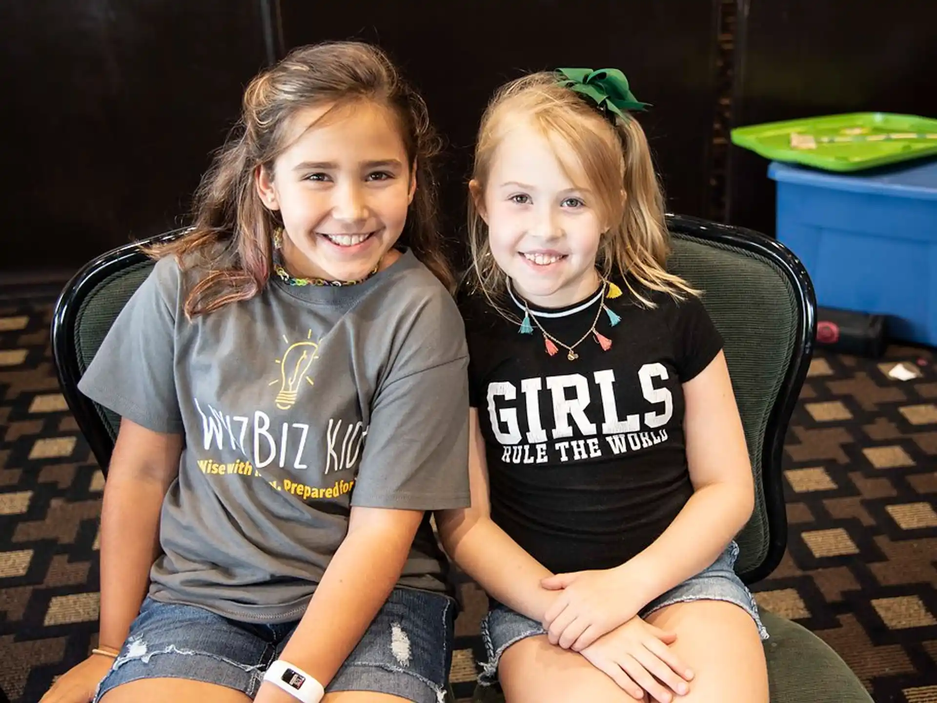 a couple of girls sitting on the ground