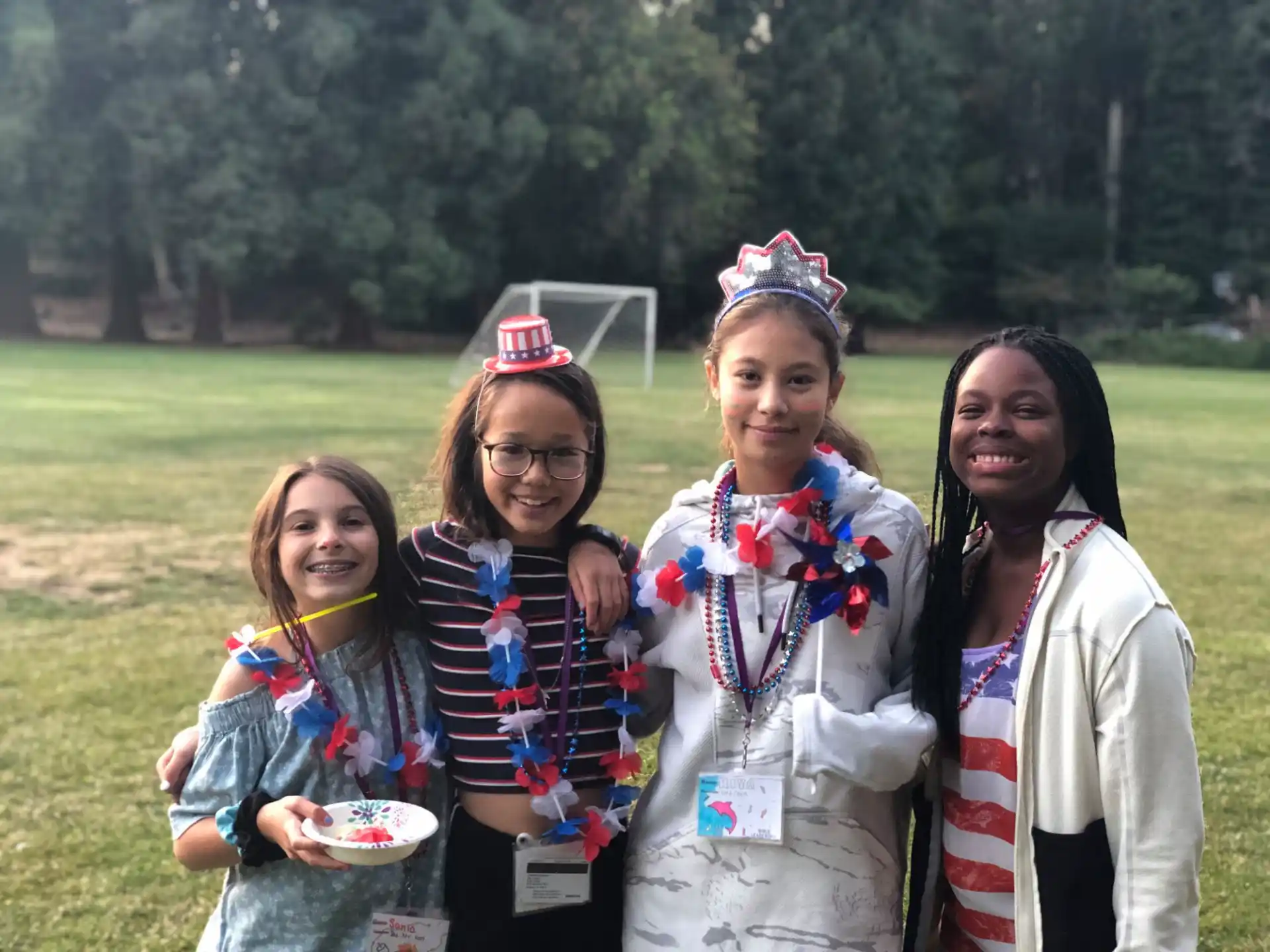 a group of girls wearing sashes and holding a trophy