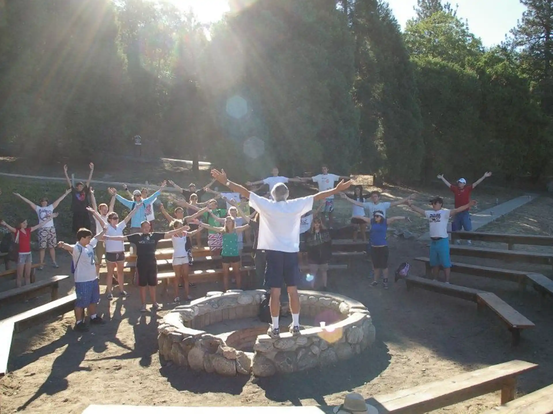 a group of people standing around a person on a rock