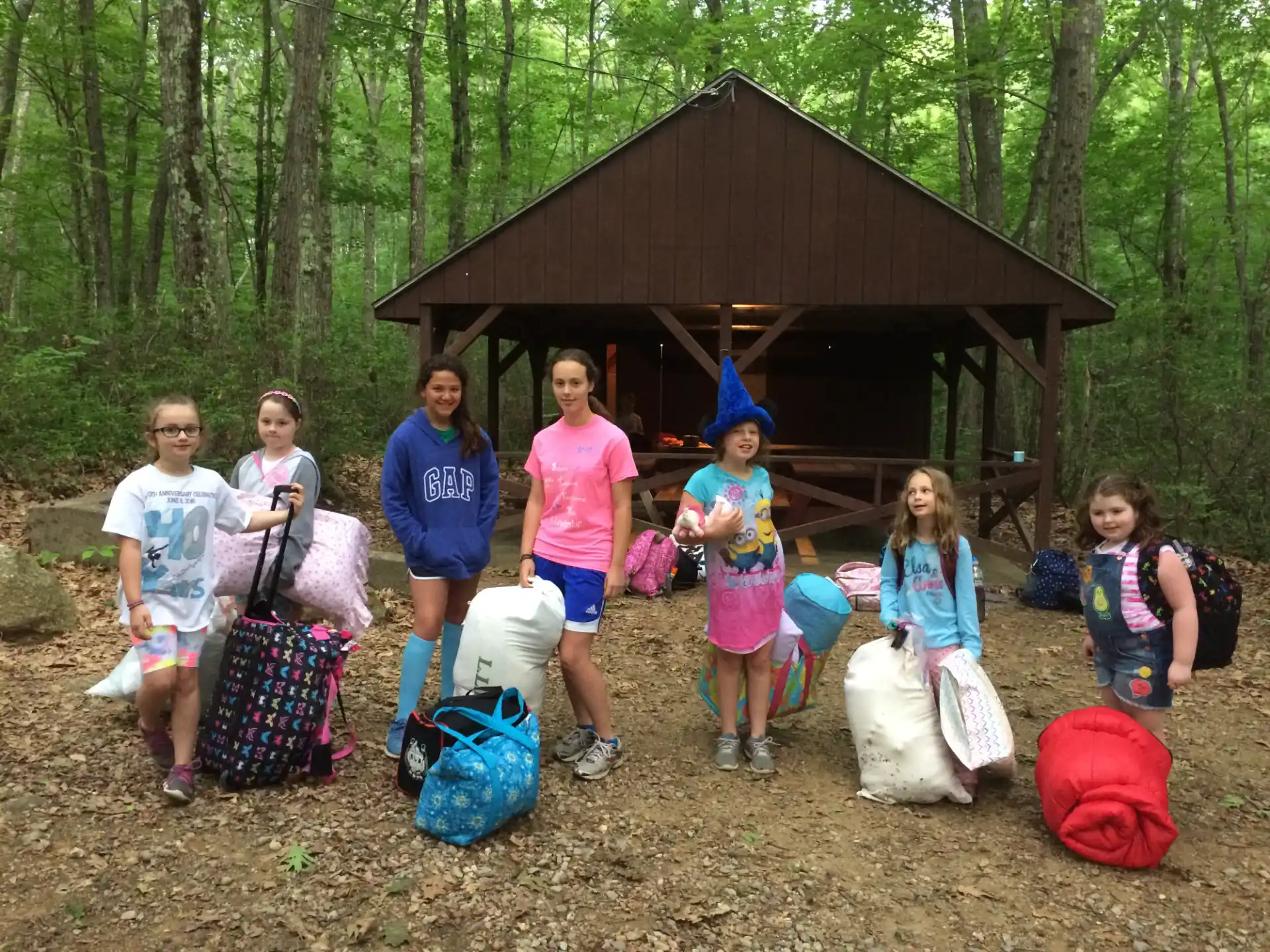 a group of people posing for a photo in front of a log cabin