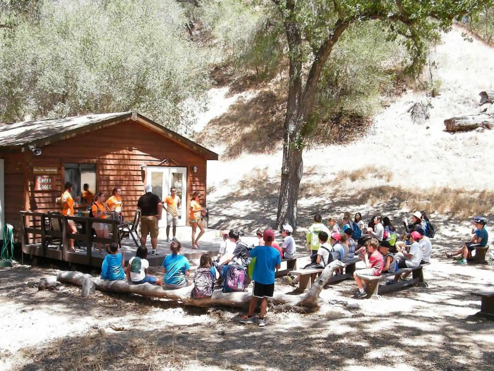 a group of people sitting on a log in front of a building