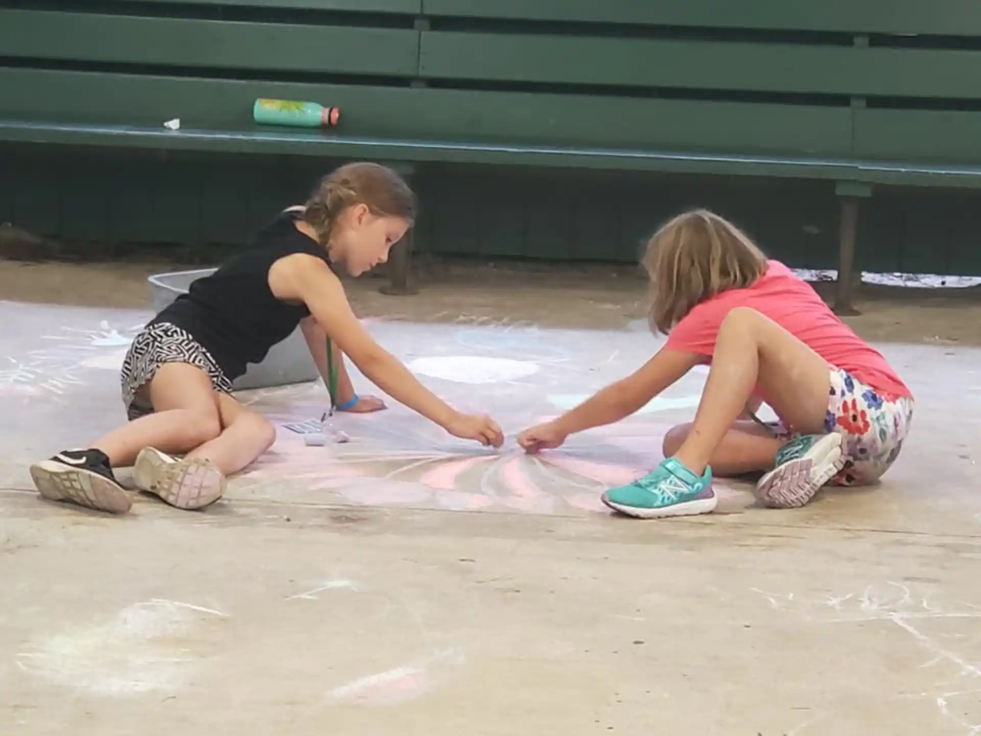 a couple of girls painting on the ground