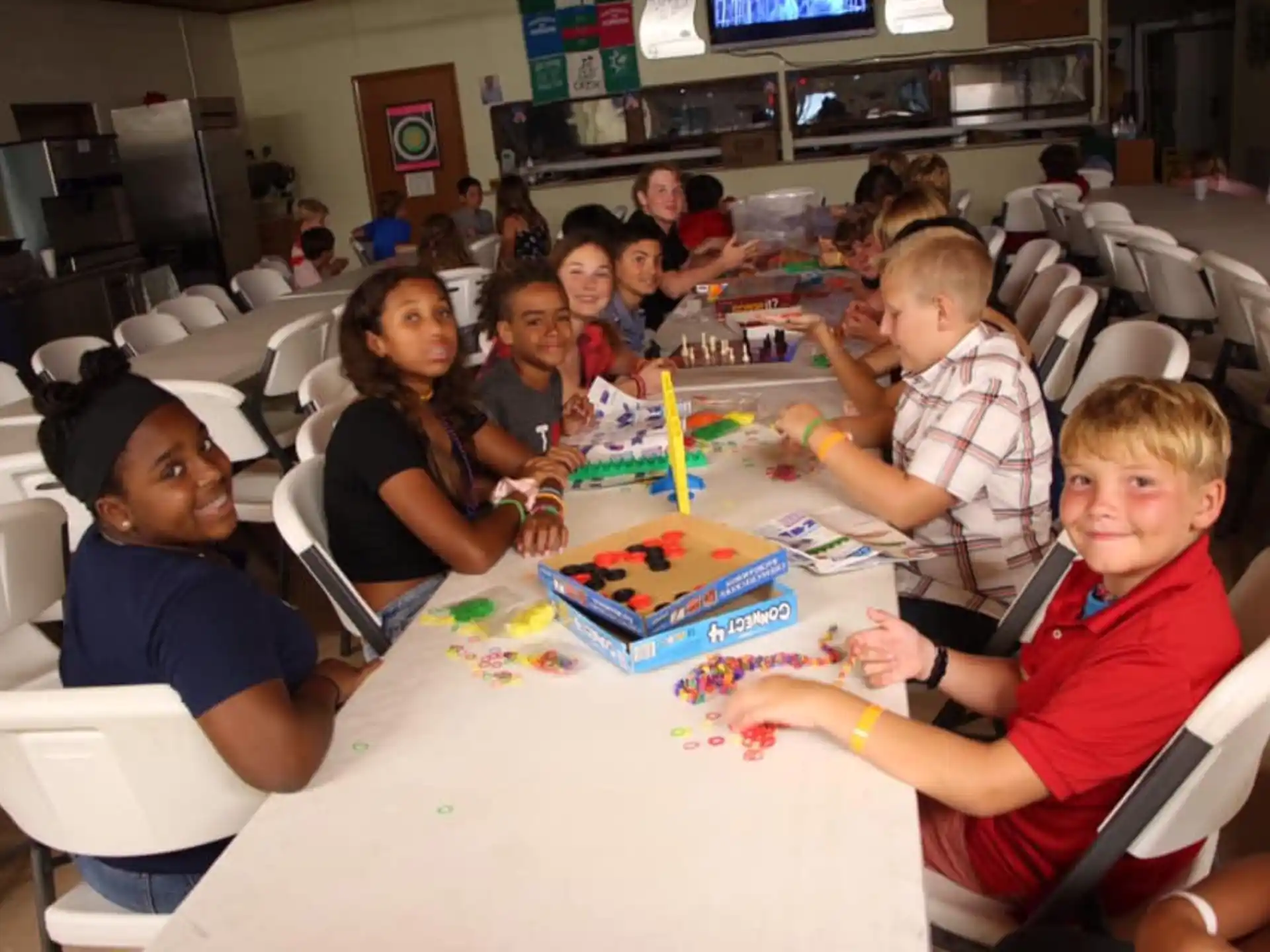 a group of children sitting around a table with a birthday cake