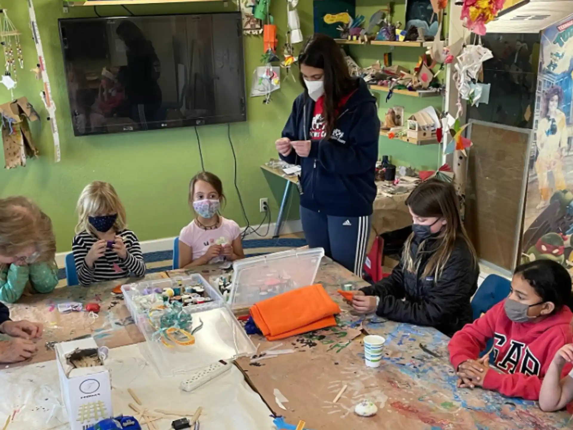 a person and several children sitting at a table