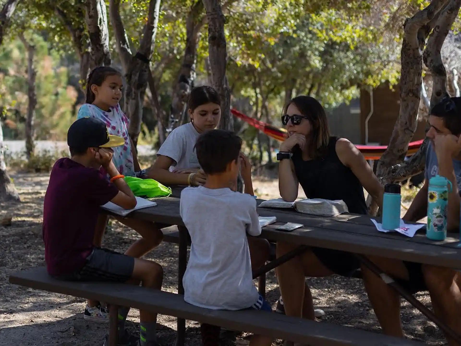 a group of people sitting at a picnic table