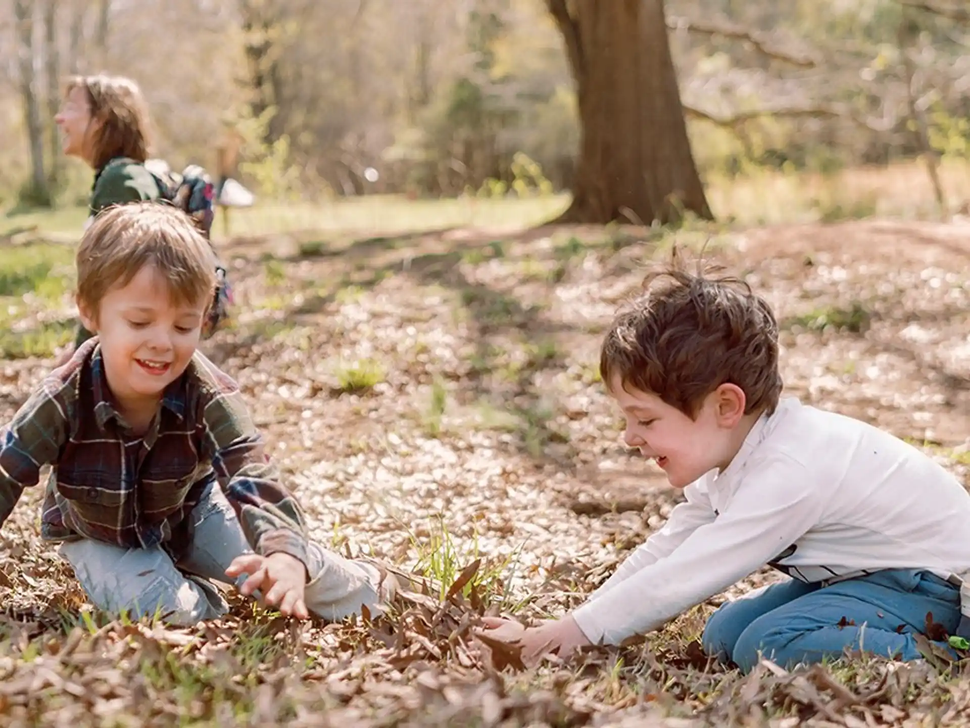 a couple of boys sitting on the ground in a park