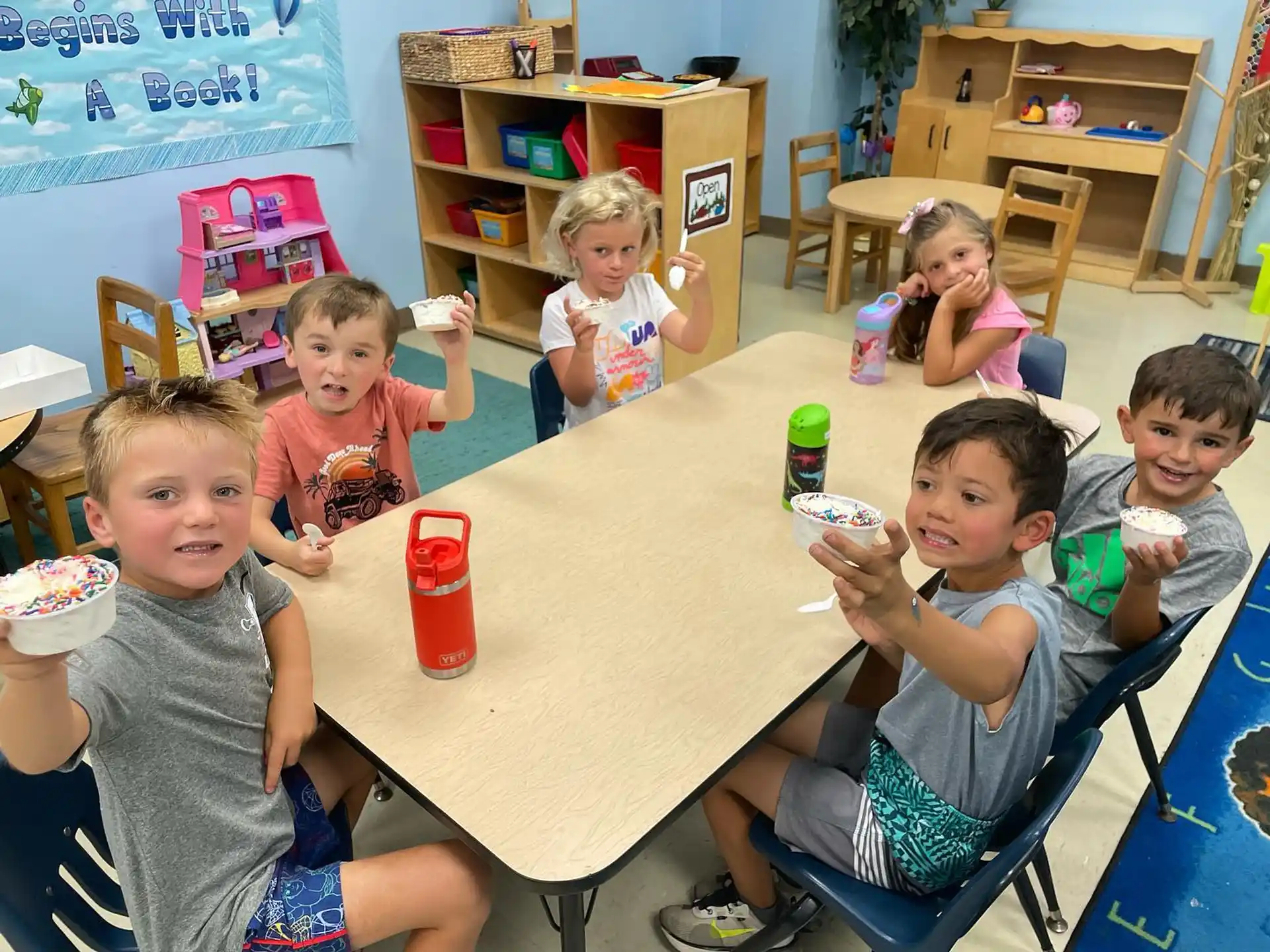 a group of children sitting around a table