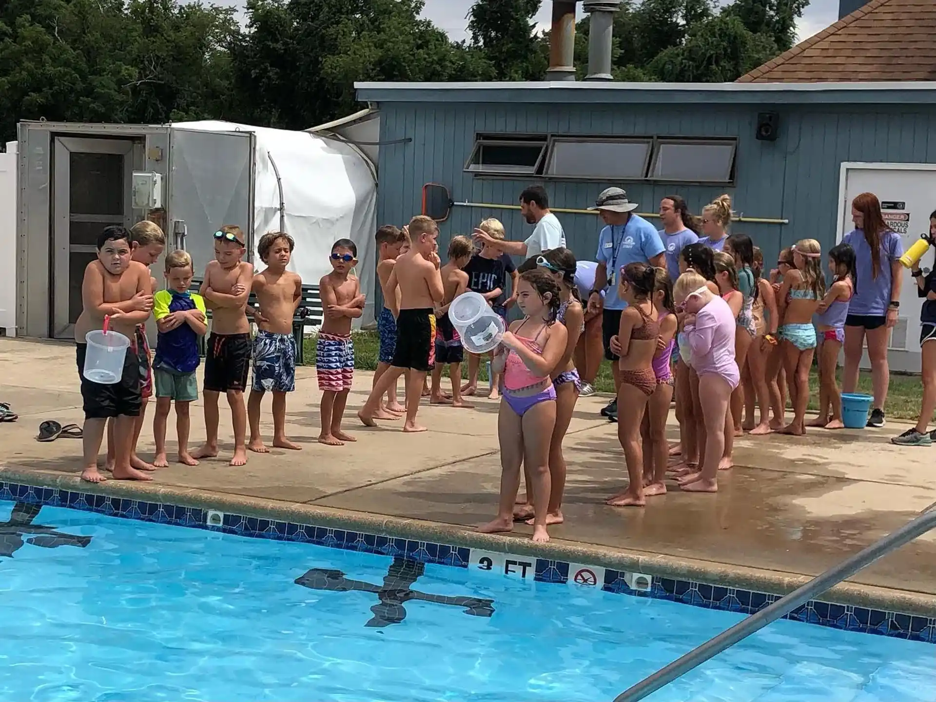 a group of people standing around a pool