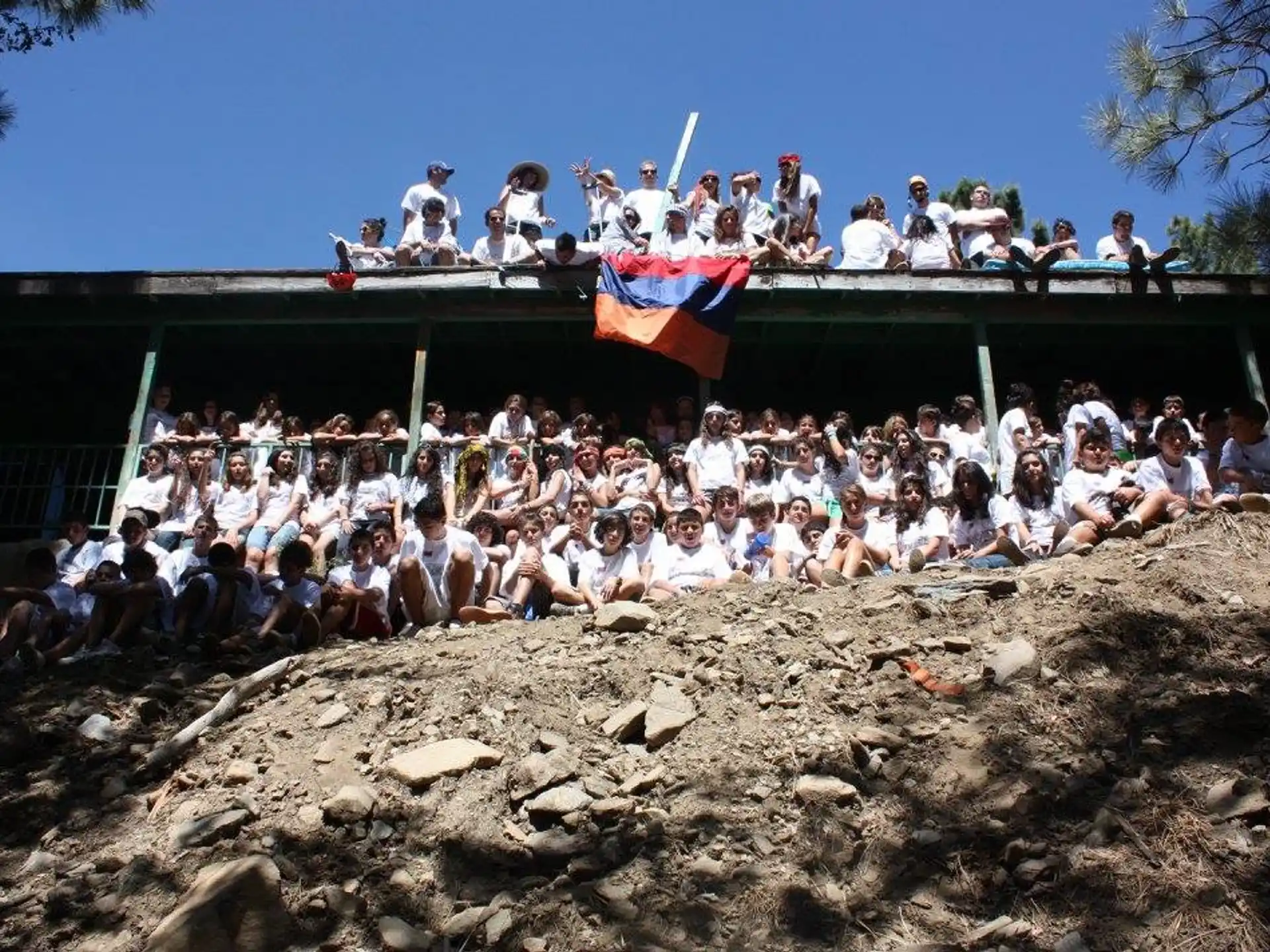 a group of people sitting on a roof with a flag