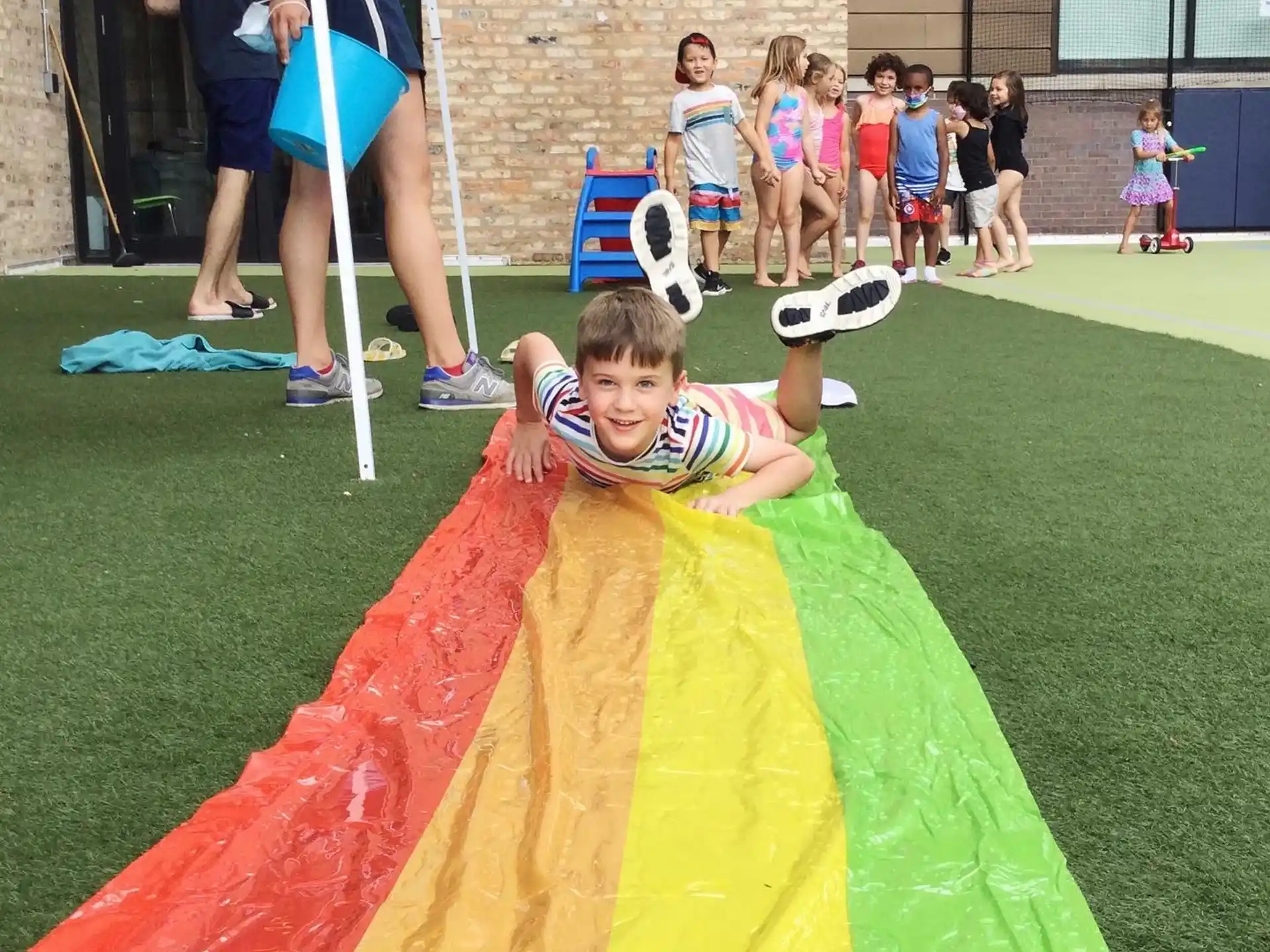 a boy lying on a yellow and red hammock in front of a group of people