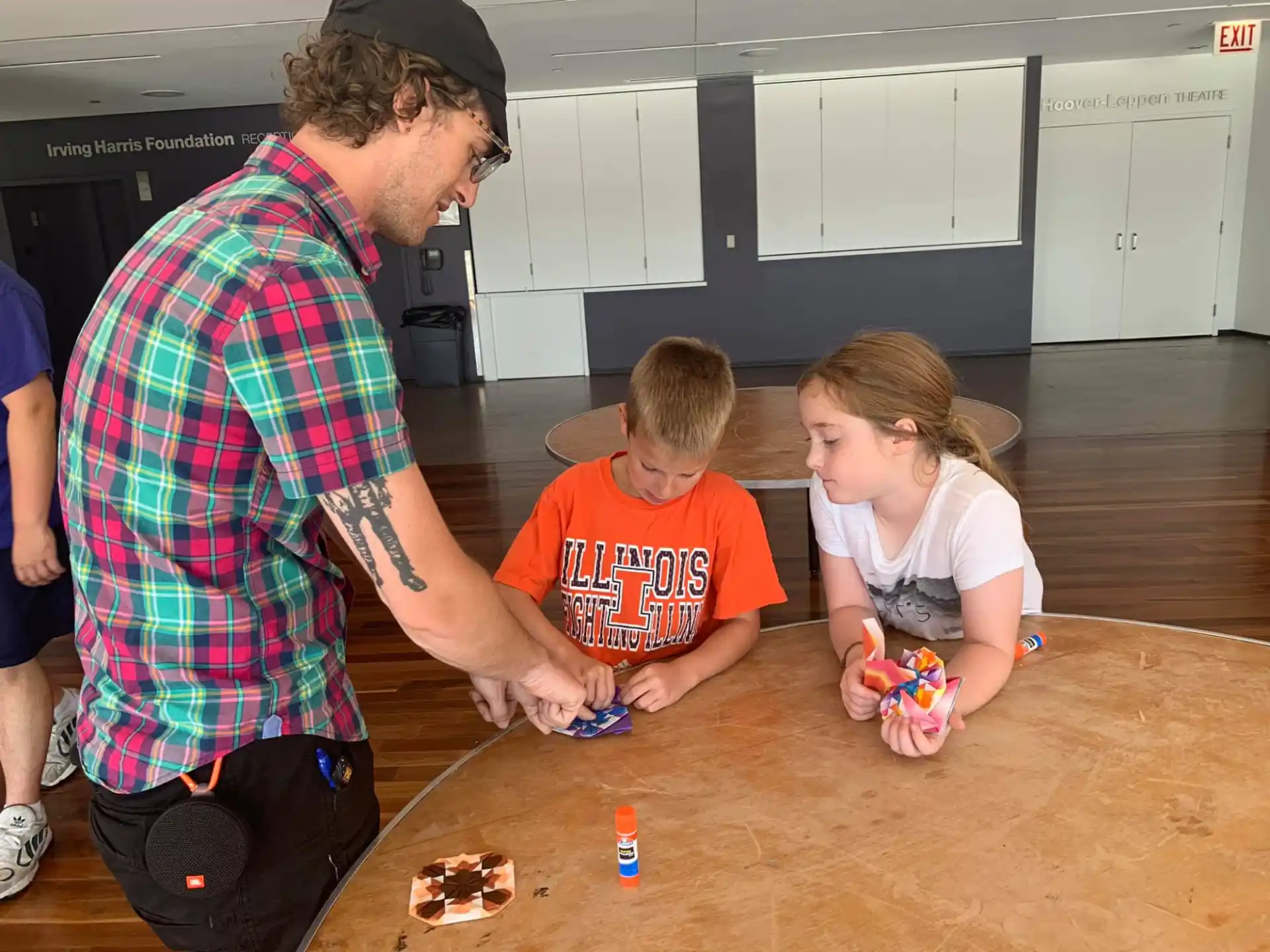 a man and two children playing with toys on a wood floor