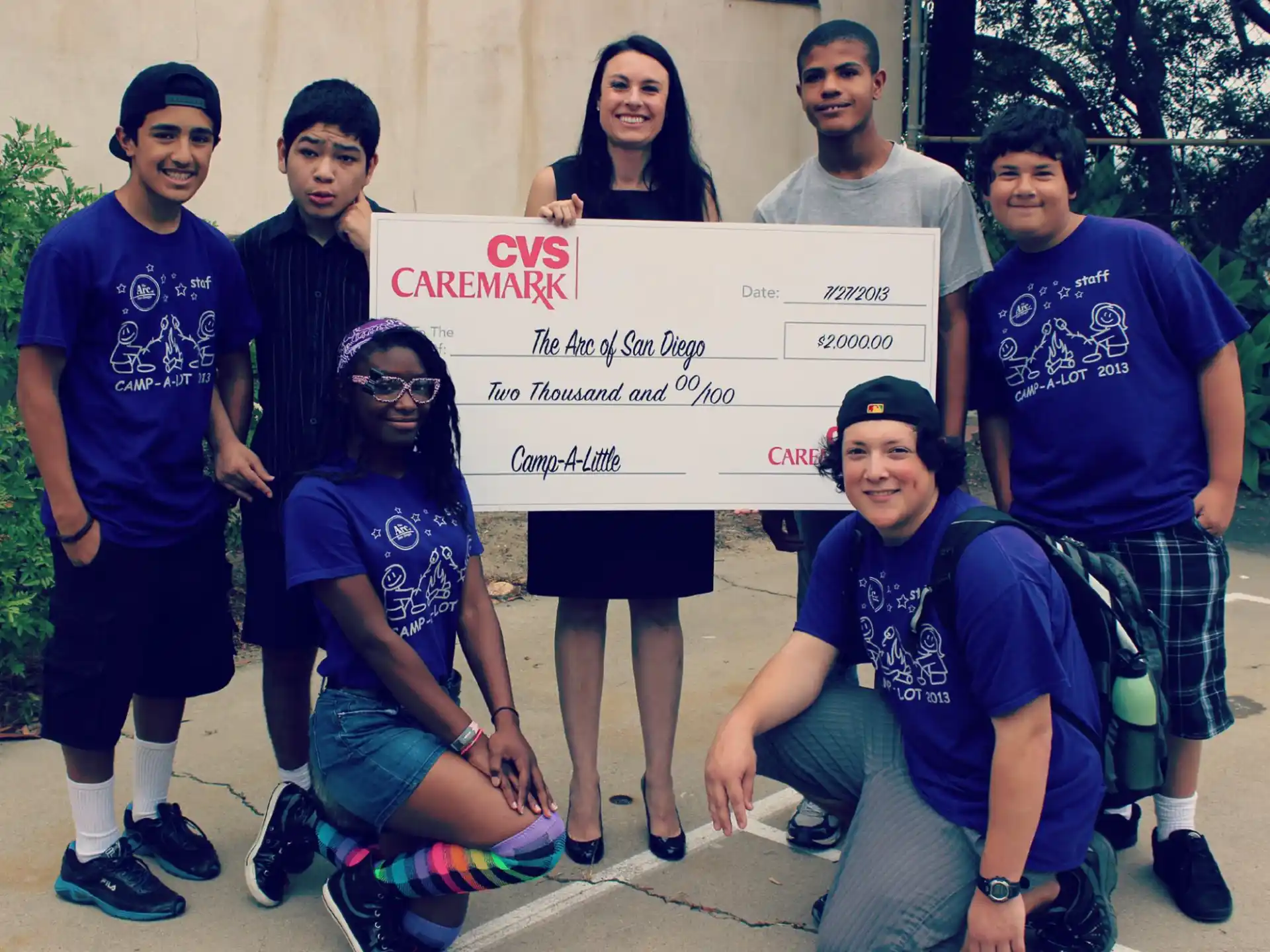 a group of people posing for a photo with a sign
