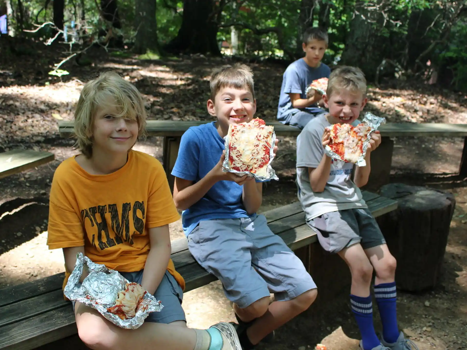 a group of kids eating pizza
