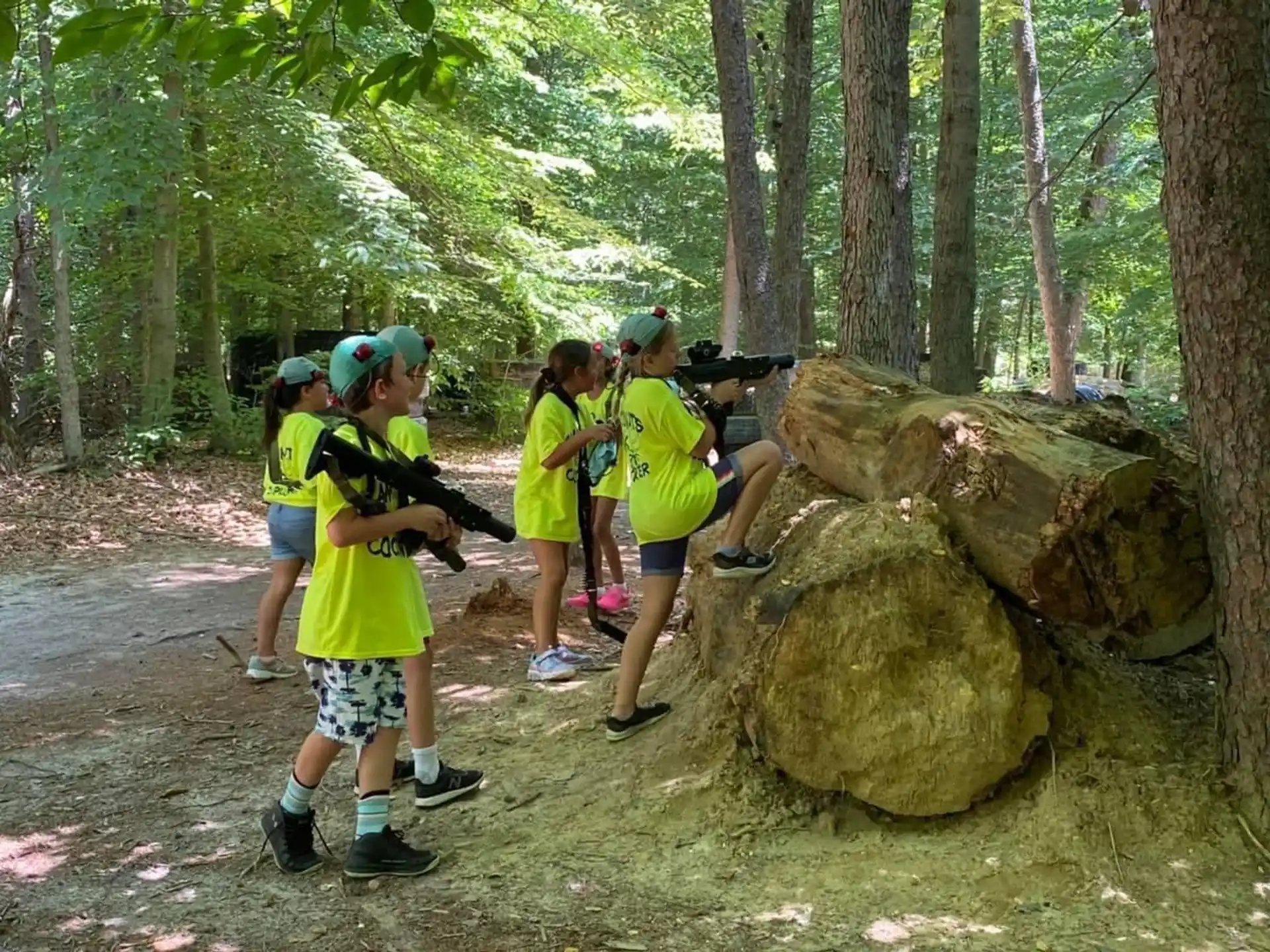 a group of people standing around a rock in the woods