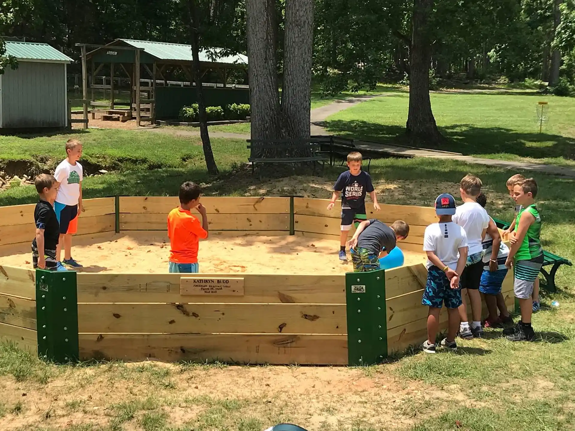 a group of kids standing around a wooden bench