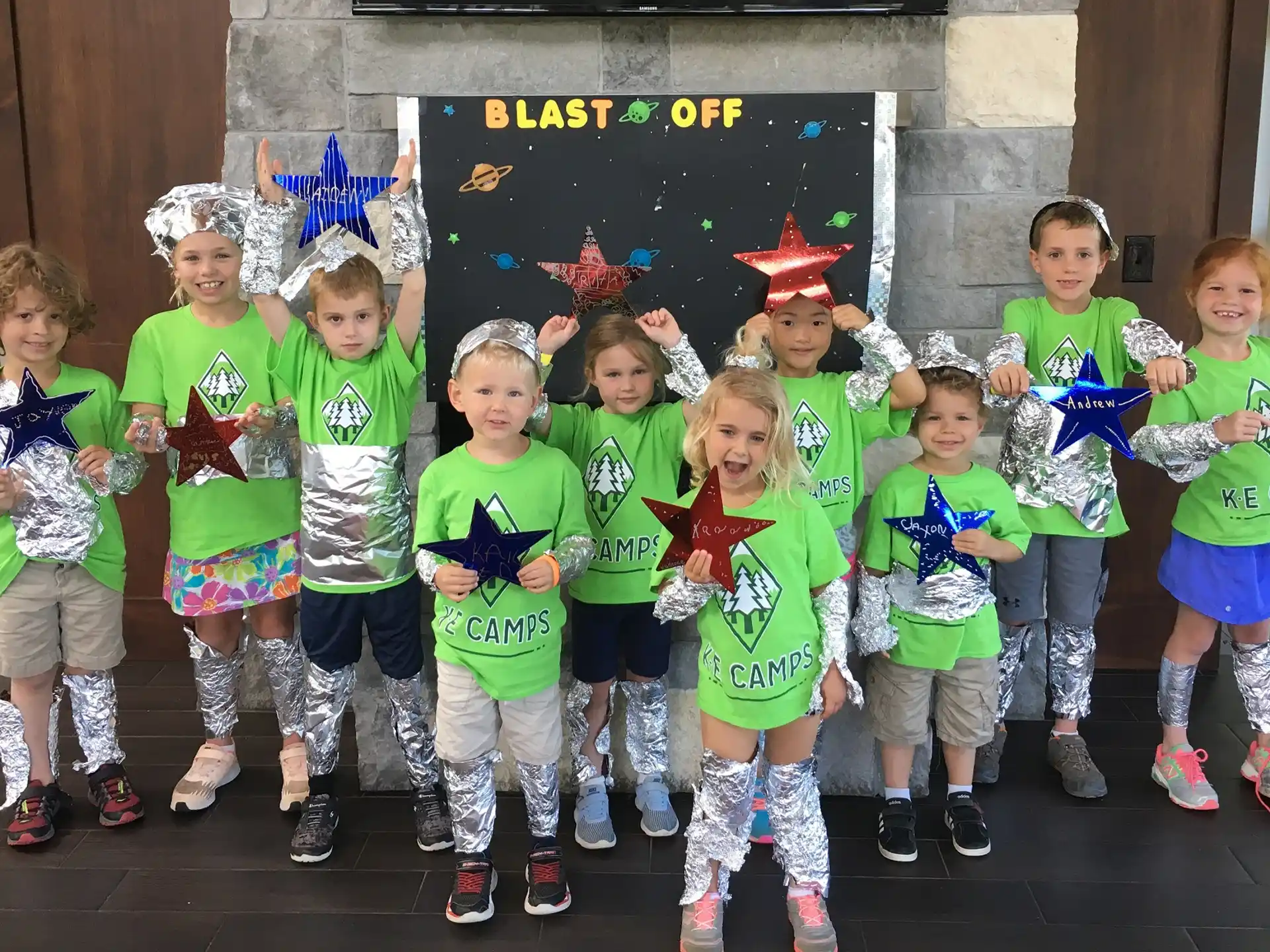 a group of children in matching green shirts and matching outfits