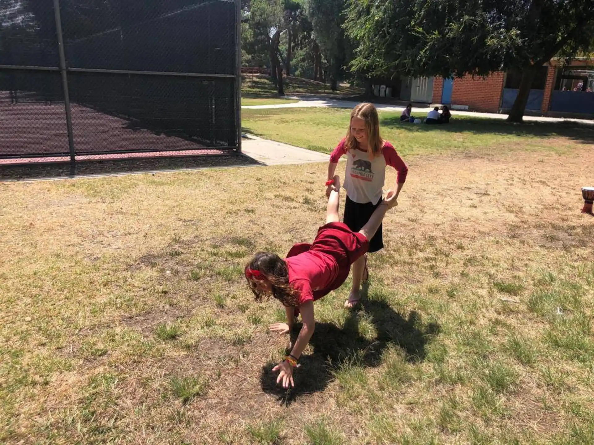 a couple of girls playing with a ball in a yard