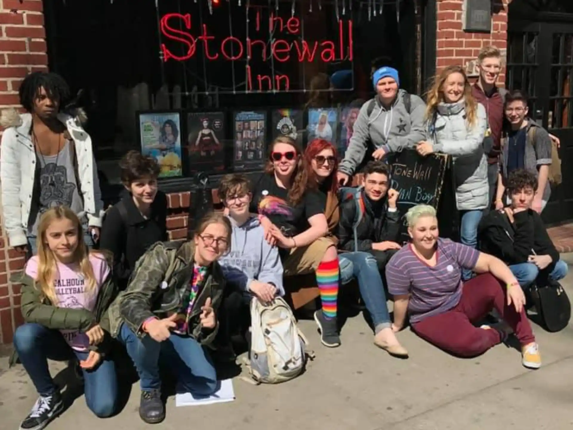 a group of people posing for a photo in front of a brick building