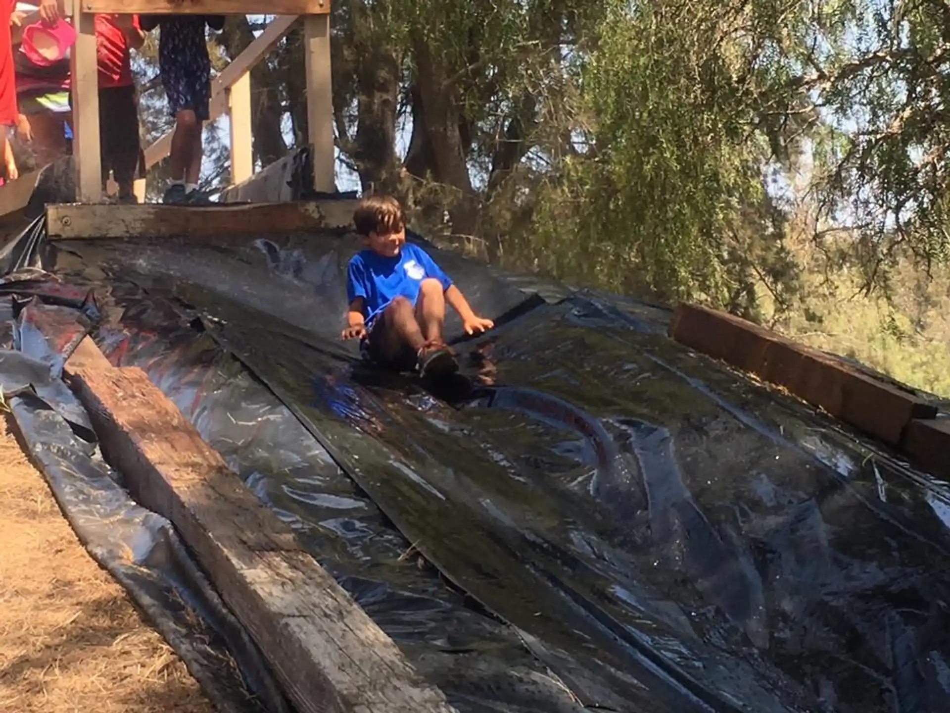 a boy sitting on a log in a stream