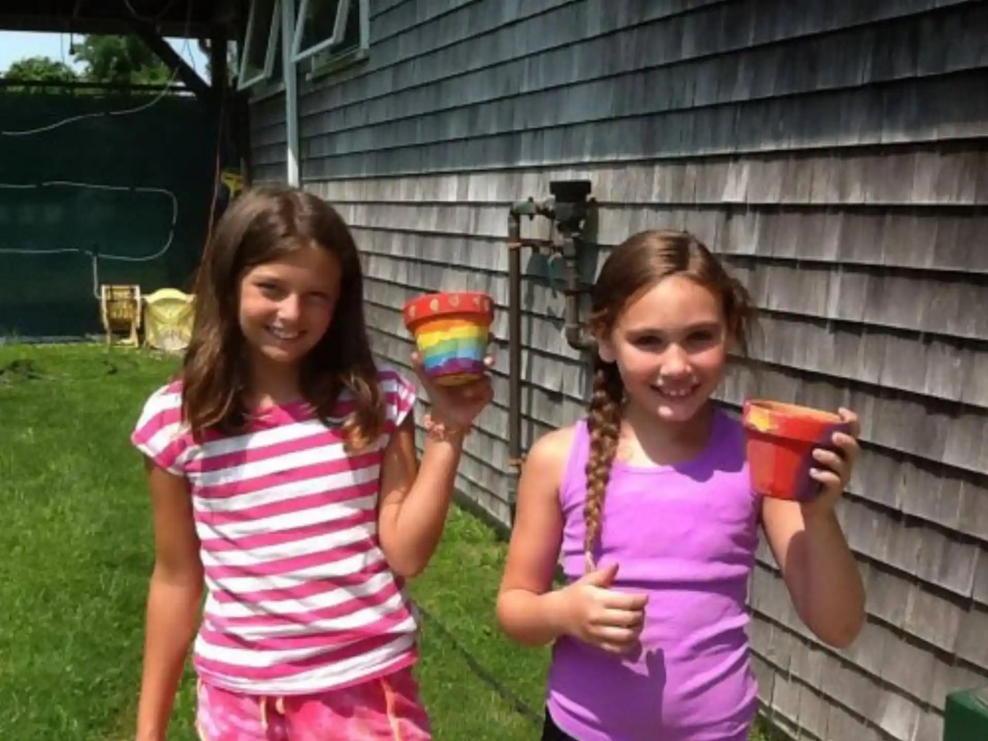 a couple of girls holding cups of food and smiling