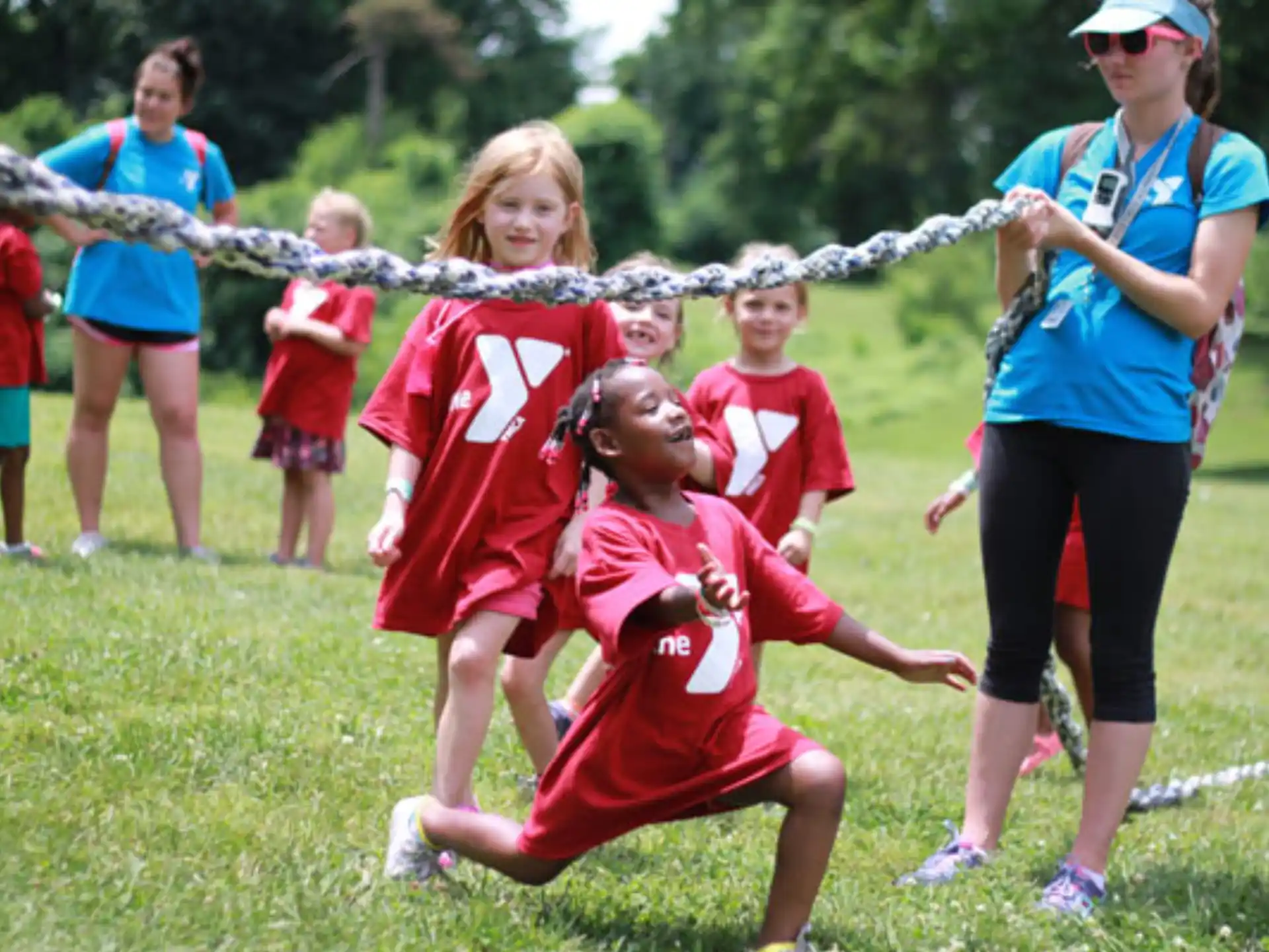 a group of children running on a grass field