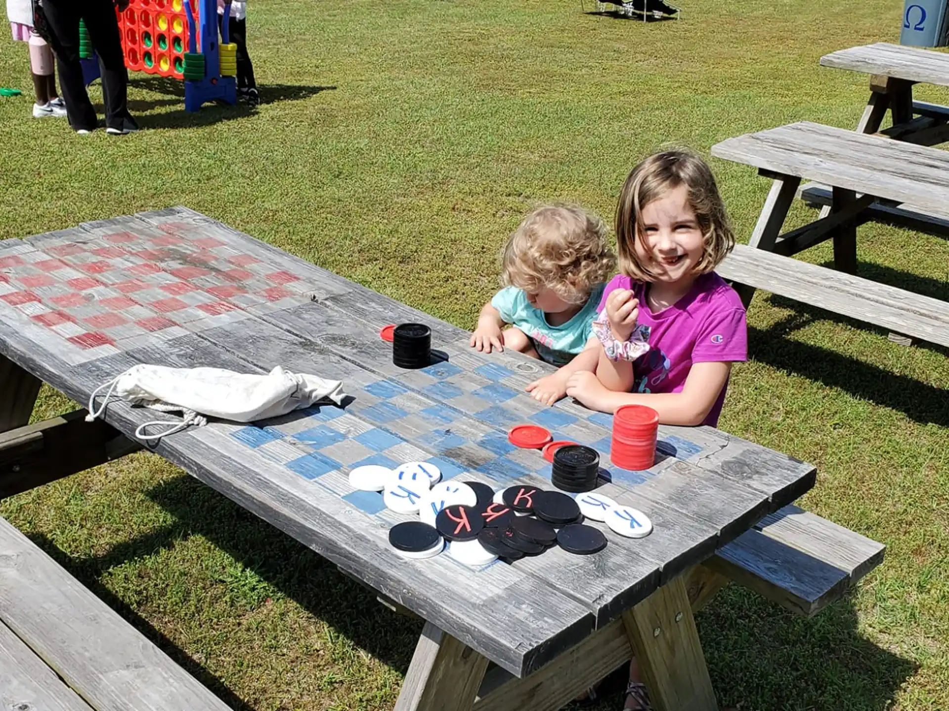 two girls sitting at a picnic table