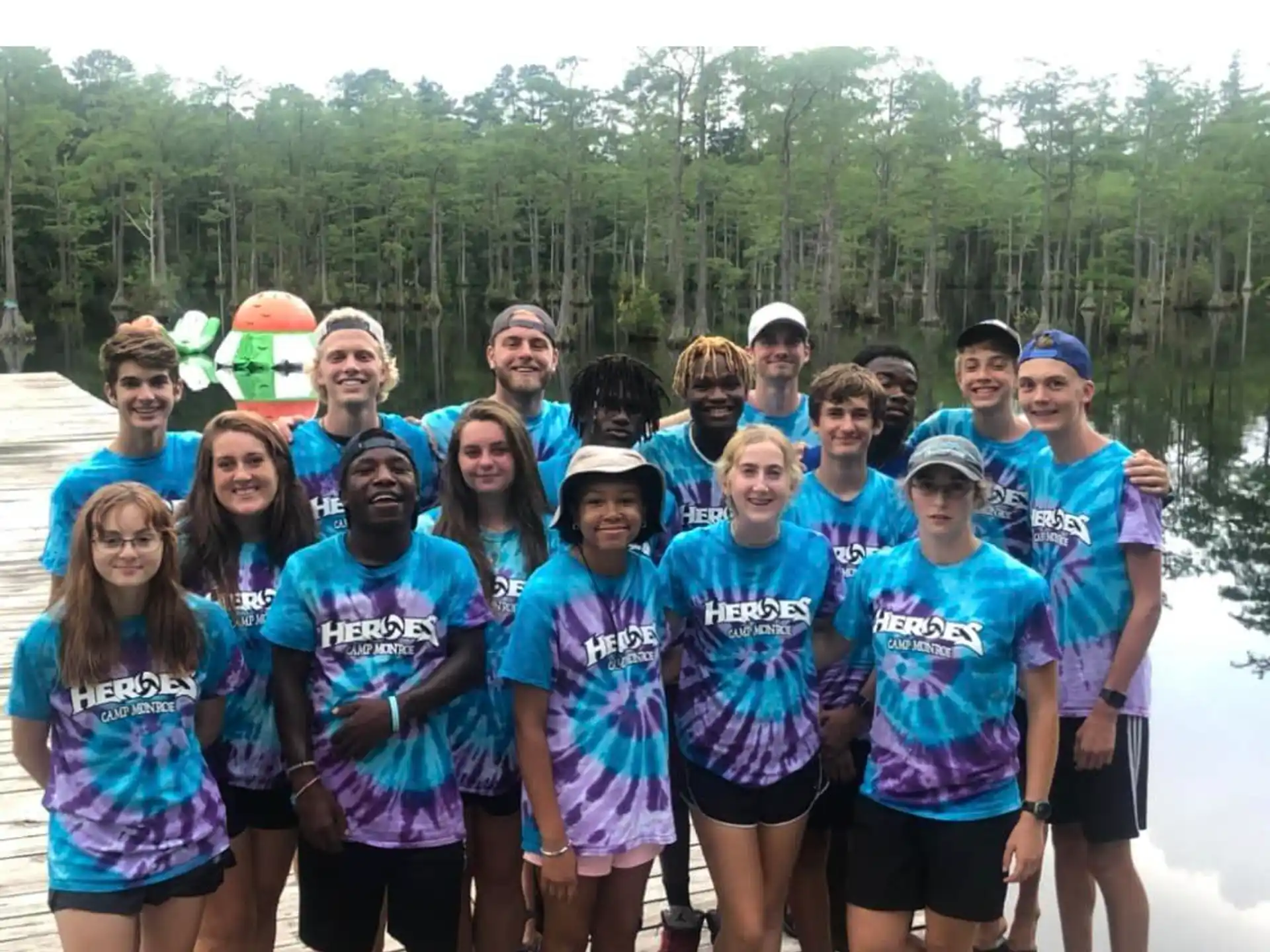 a group of people wearing matching t-shirts and standing in front of a river