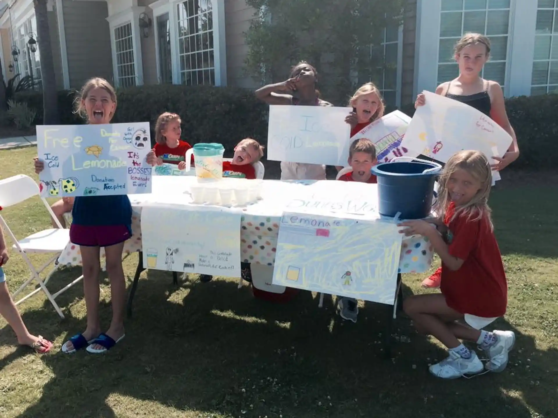 a group of children sitting around a table outside