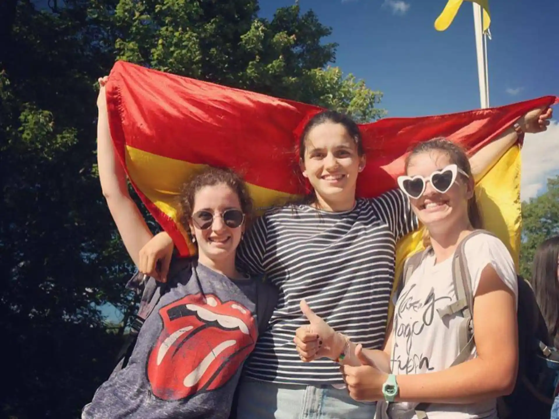 a group of people posing for a photo in front of a flag