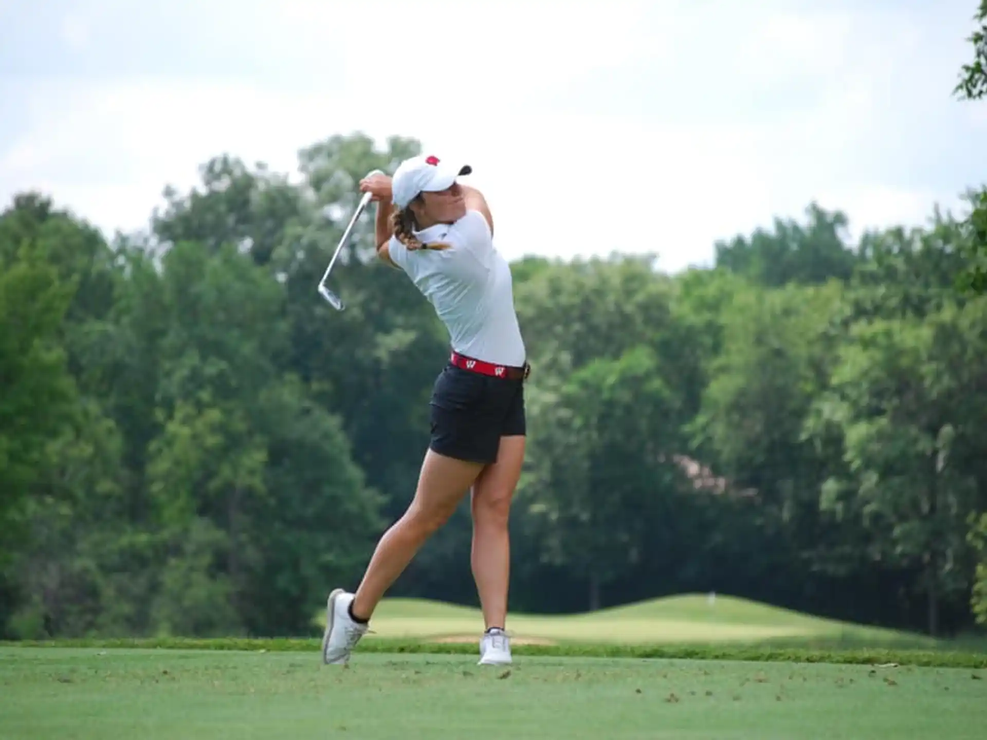 a woman swinging a golf club