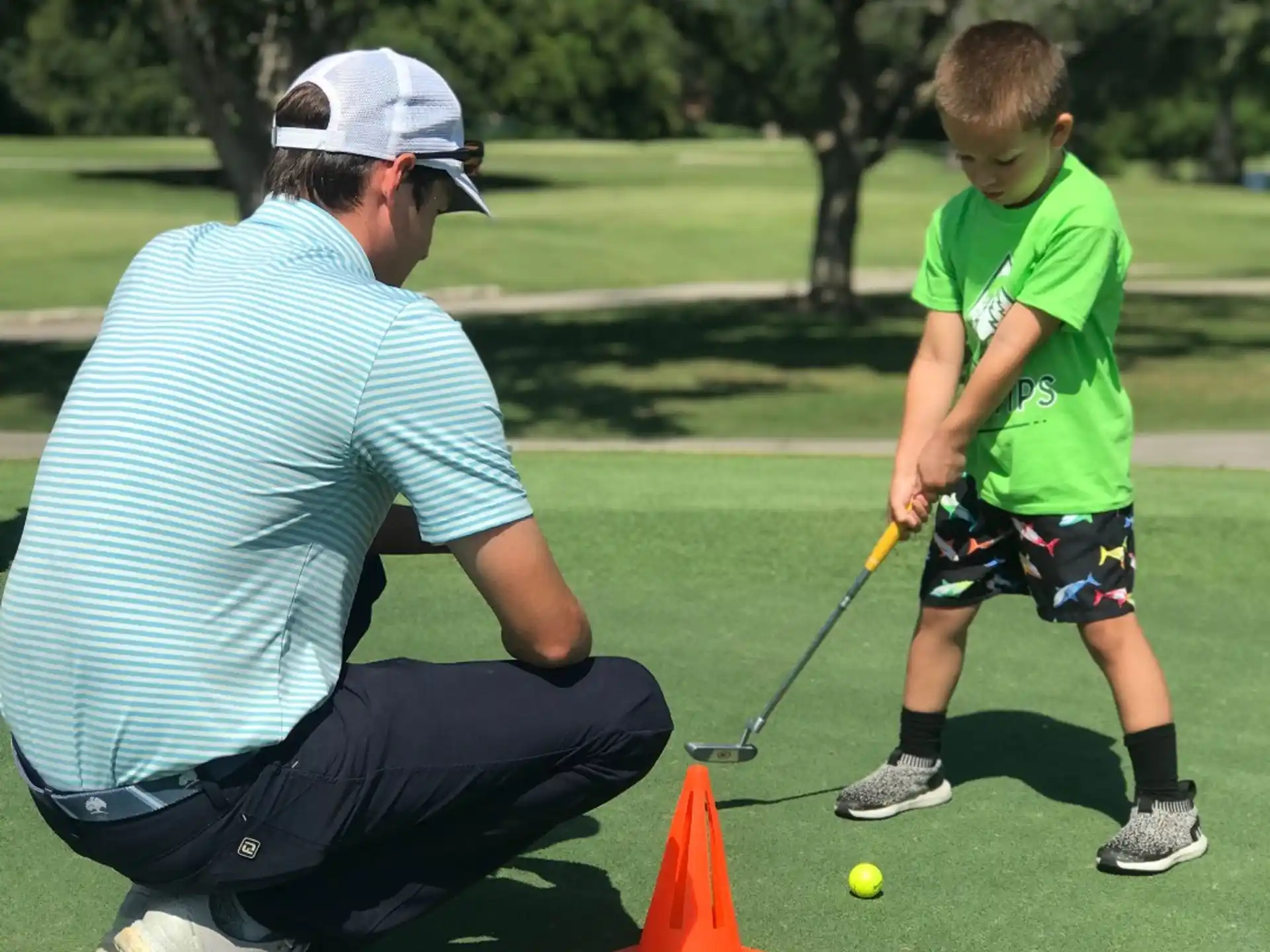 a person and a boy playing golf