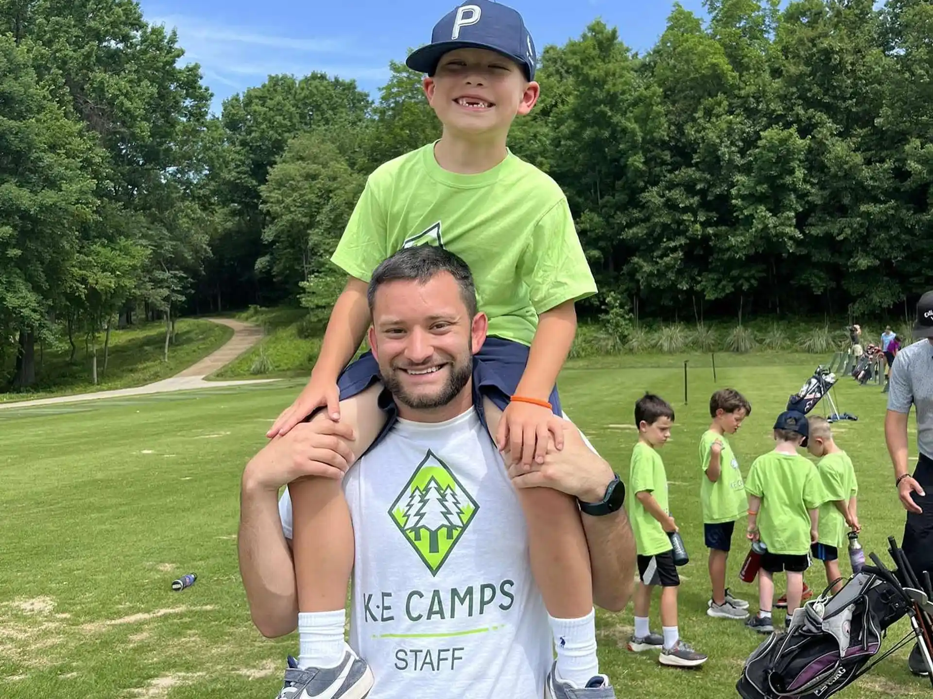 a person holding a child on the shoulders in front of a group of people