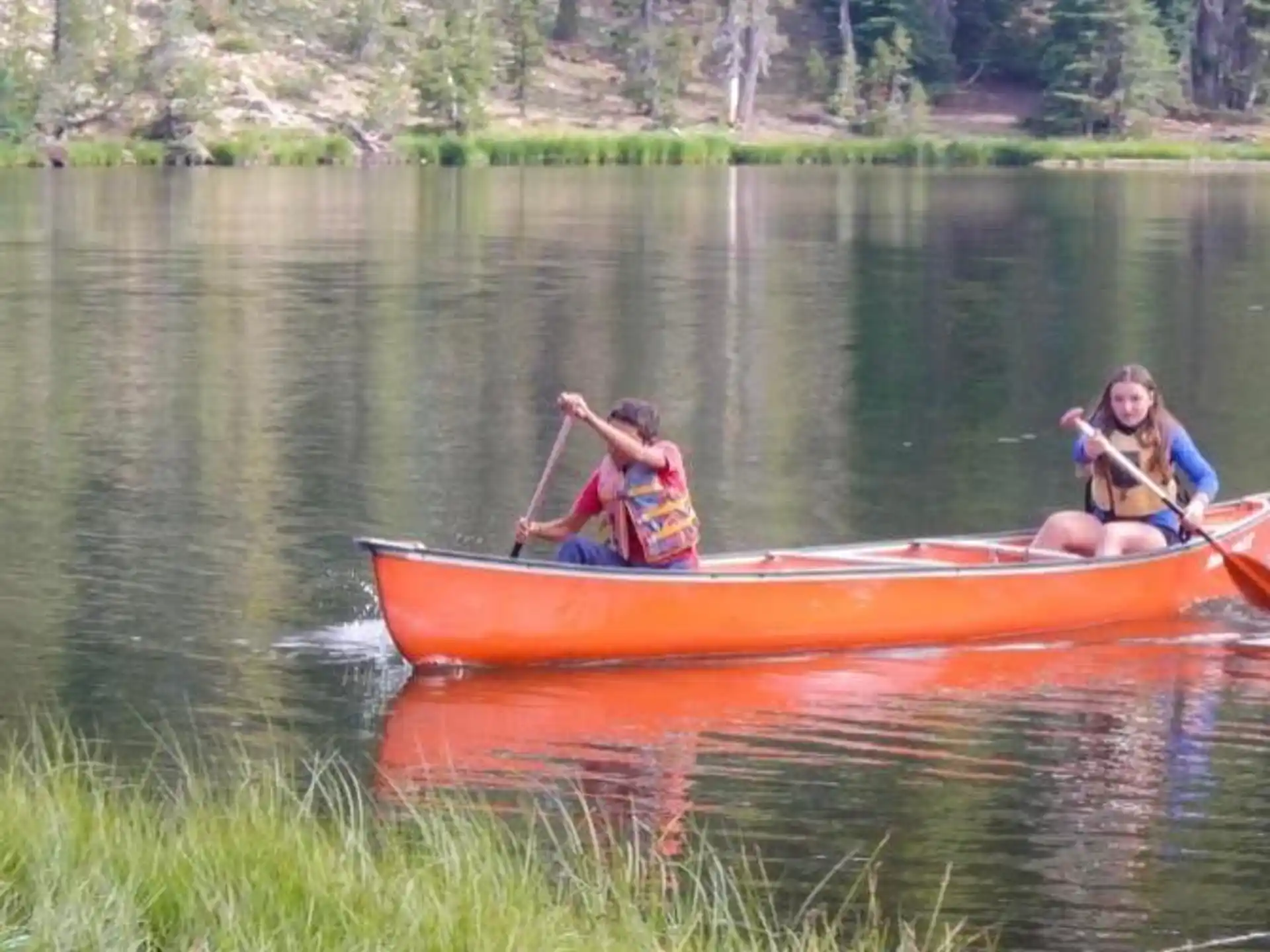 a couple of people in a canoe on a lake