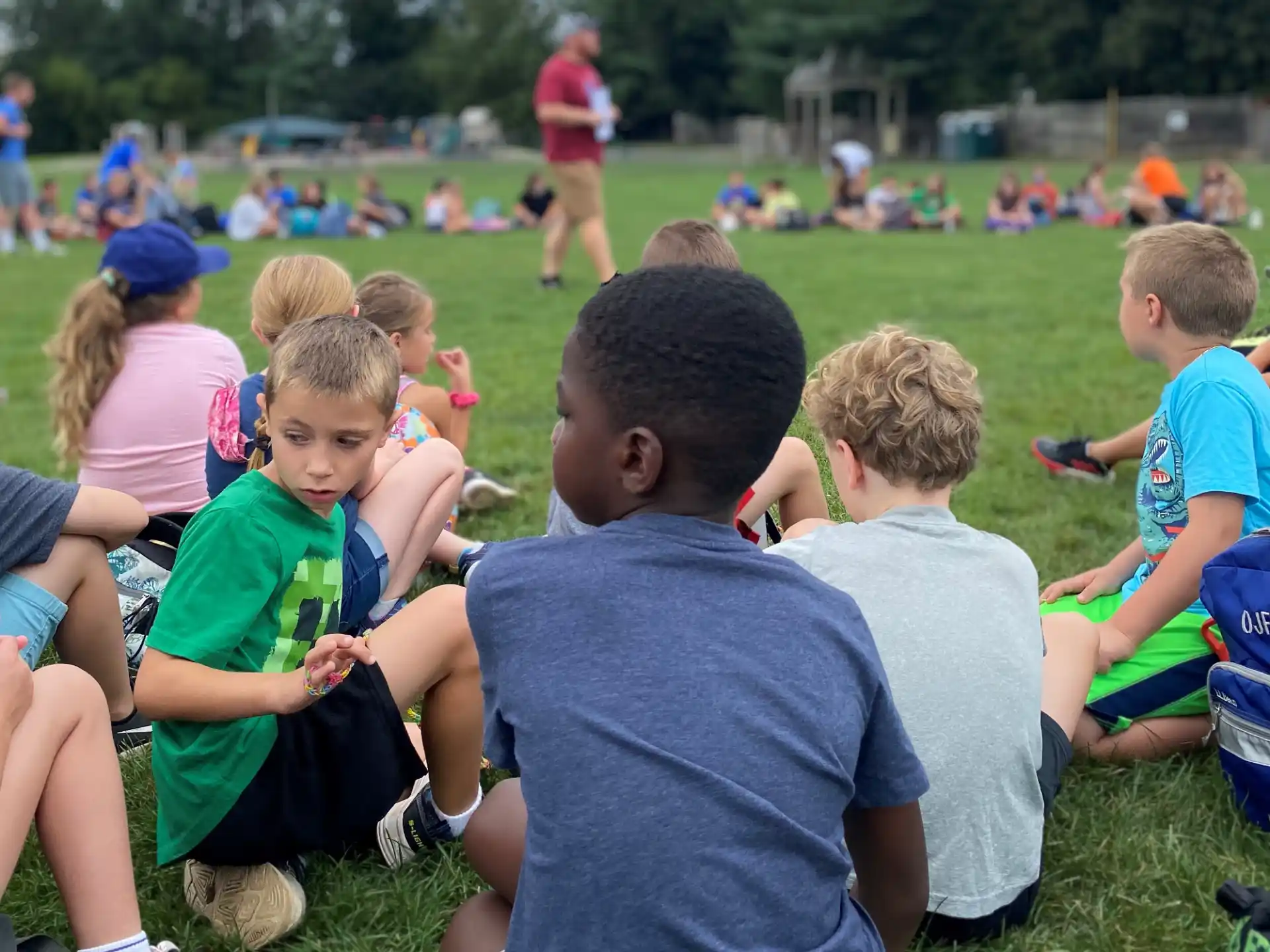 a group of children sitting on the grass