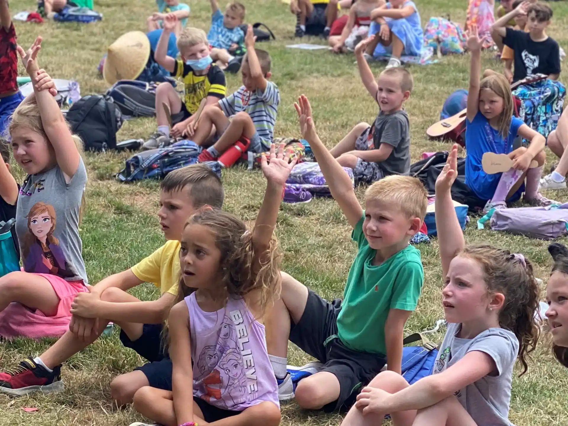 a group of children sitting on the grass