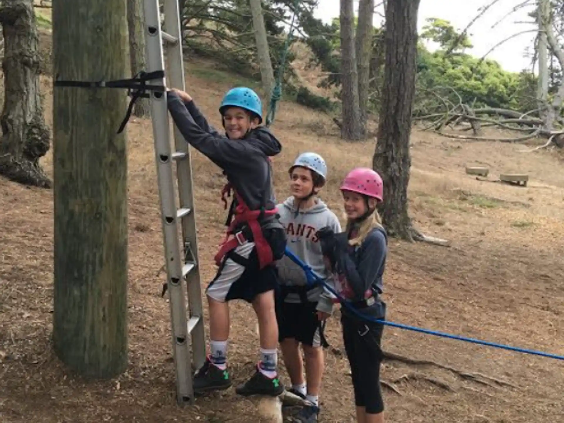 a group of people wearing helmets and harnesses posing for the camera